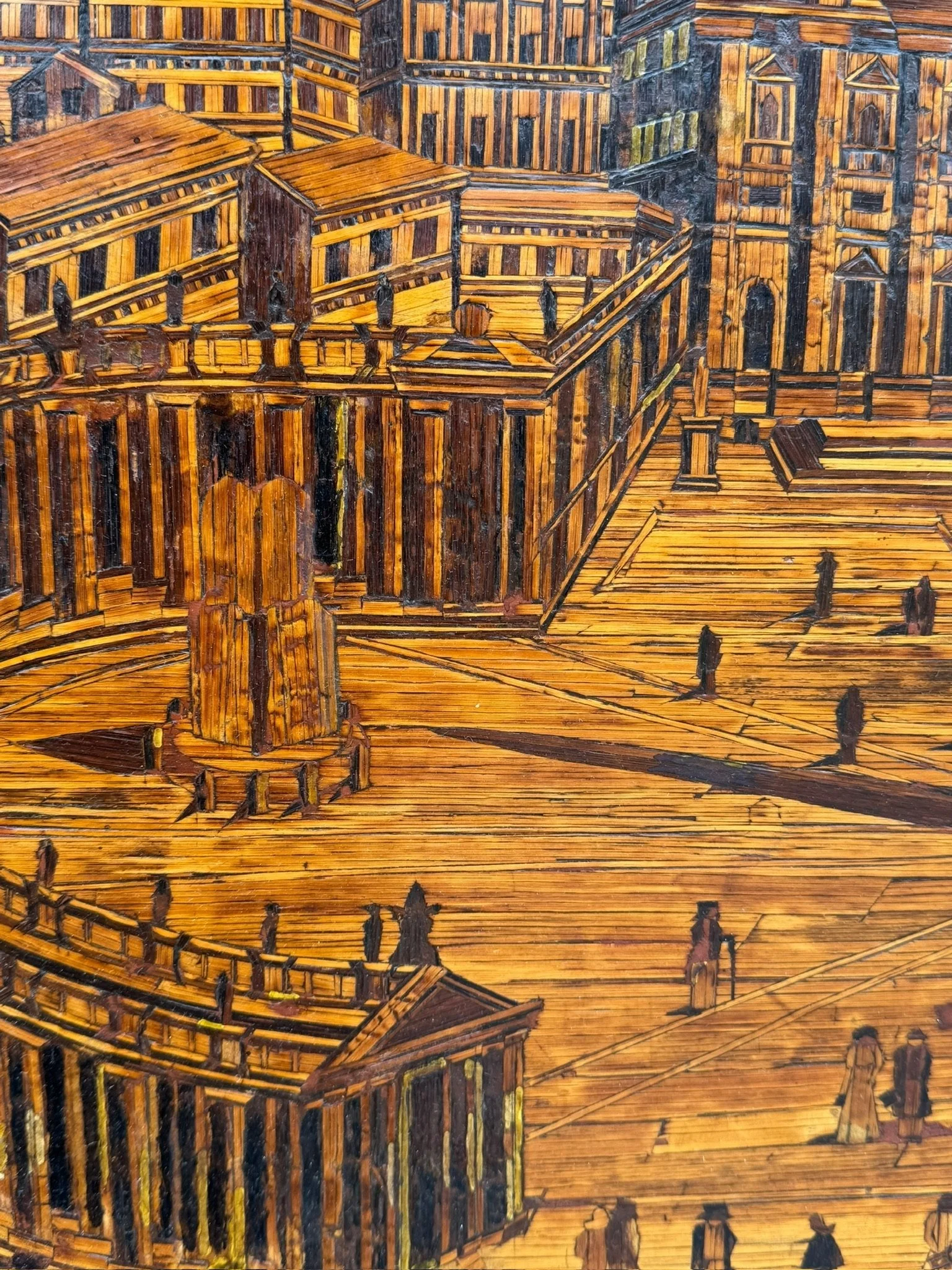 A detailed wood inlay artwork depicting a historical waterfront scene with large, ornate buildings, a walkway with people, and architectural details in warm wood tones.
