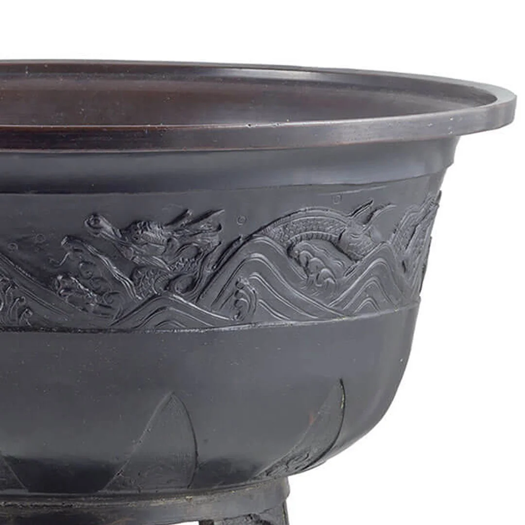 Close-up of a black plastic or metal decorative container with dragon and wave motifs.