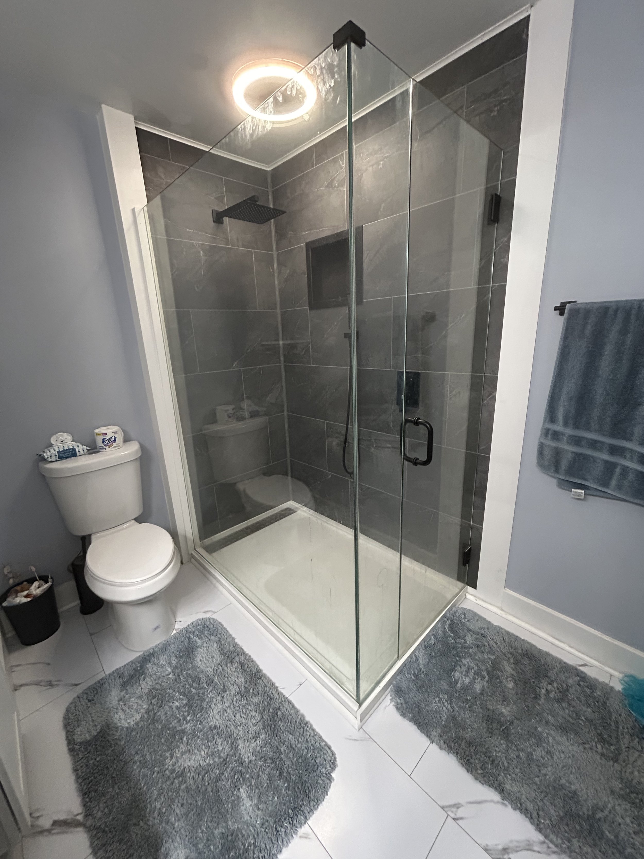 "Cracked Slate" grout-free wall tiles with a "Black Ice" recessed niche work perfectly with matte black fixtures.