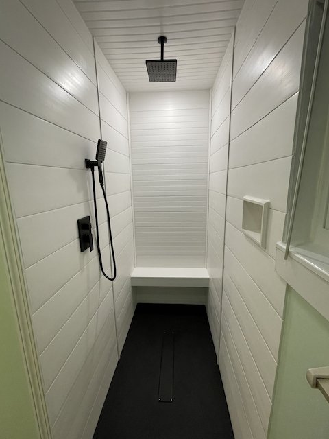 Custom-built, black, acrylic shower base in a deep alcove shower