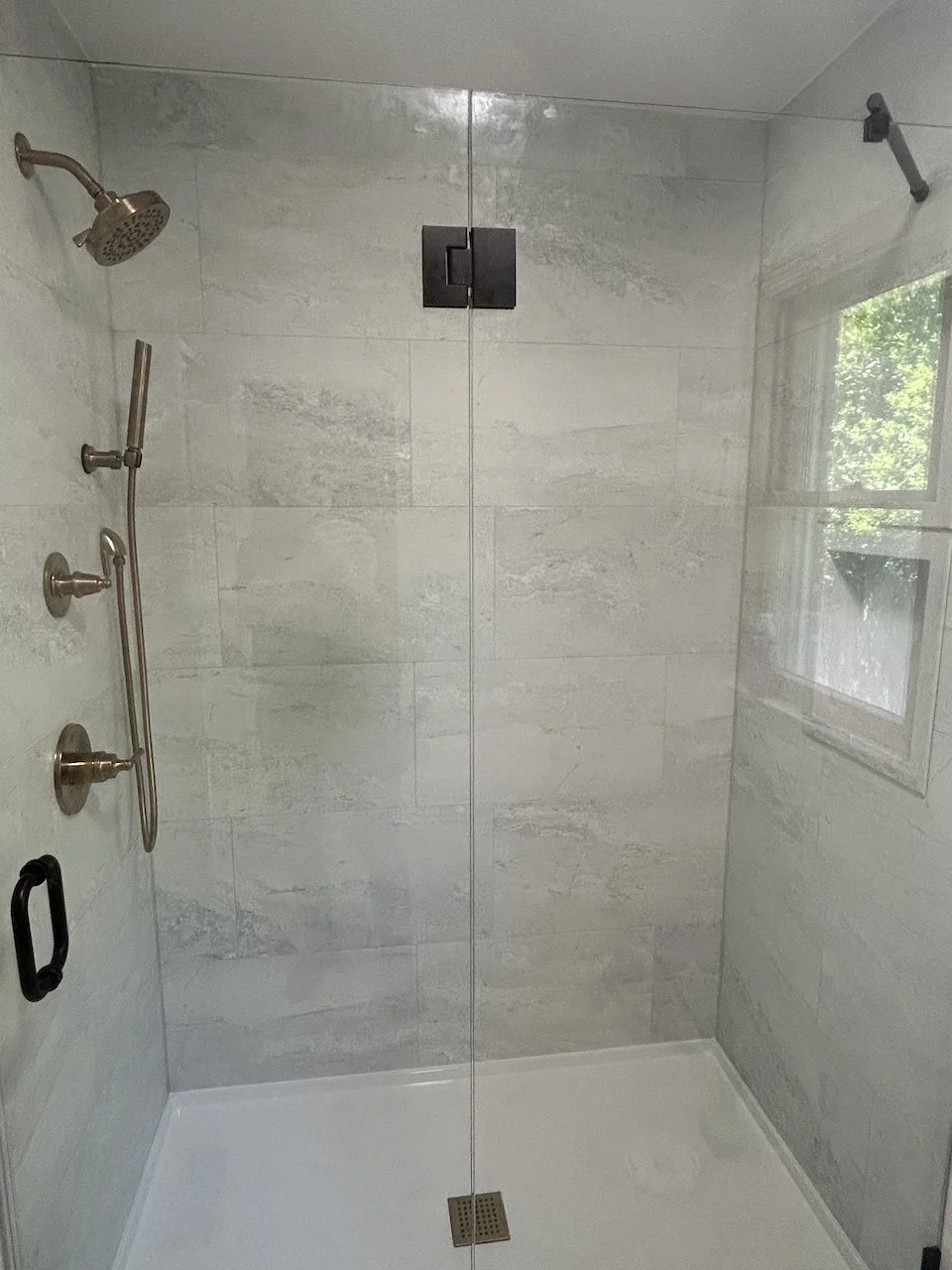 We don't always agree with our clients but it's their shower so absolutely, we'll use black shower-door hardware with brushed nickle shower controls.