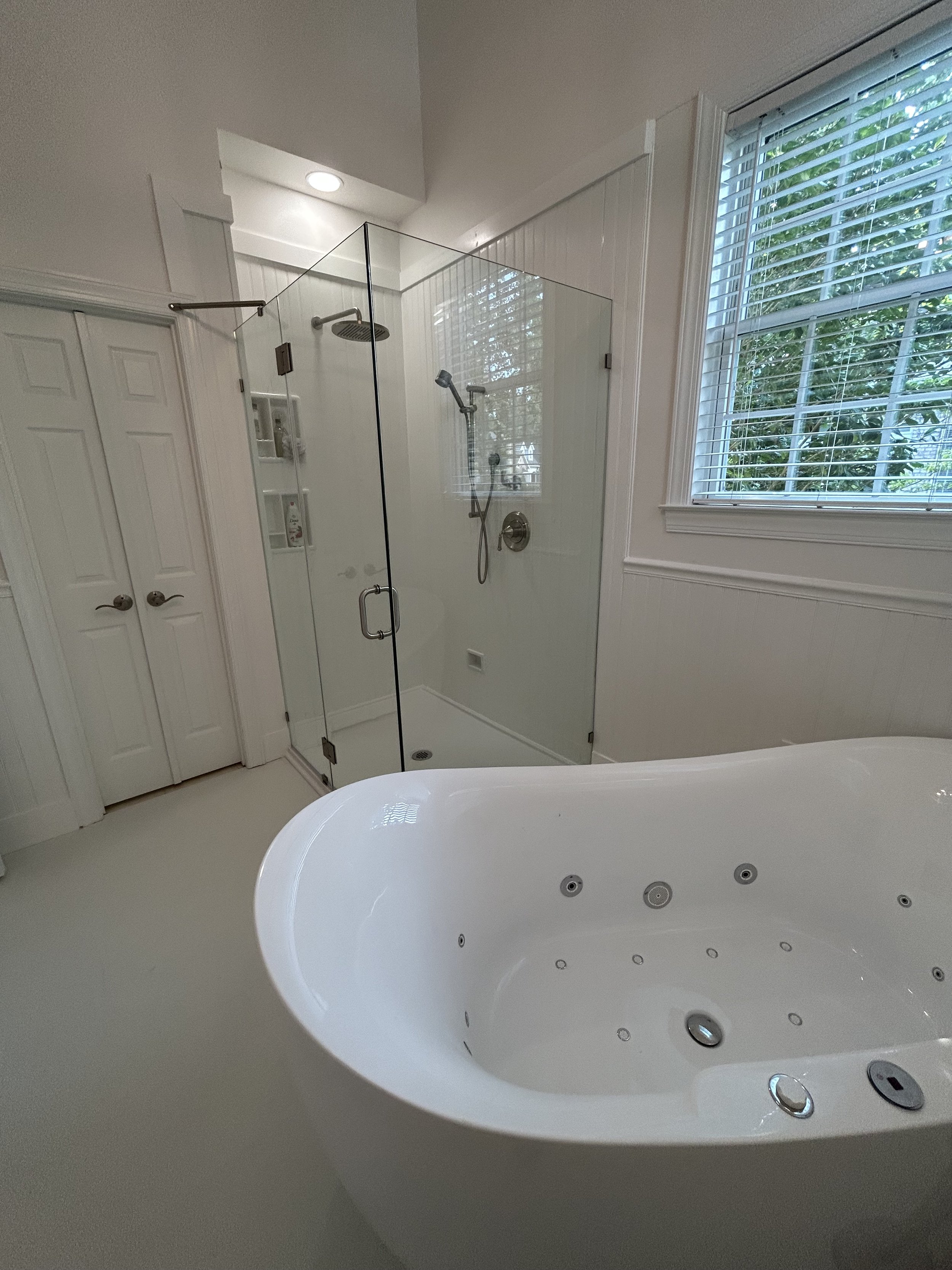 A large tiled jetted tub was replaced with this beautiful, stand-alone jetted tub that takes up half the space allowing for this enlarged walk-in shower