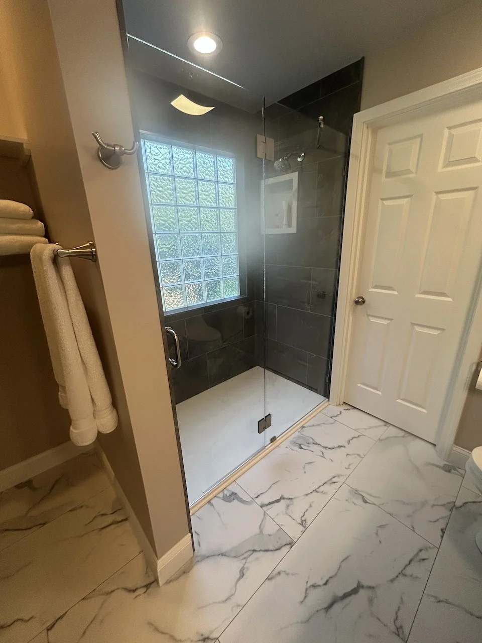 This new shower was previously an unused tub, and the changing area was the old shower.