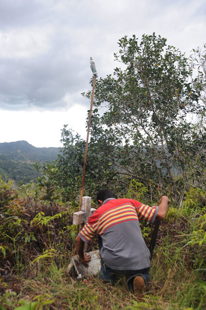  A local historian, Neftali Soto, cleans the dirt off of a plaque which memorializes Toño Bicicleta in the upper mountain region of Lares, Puerto Rico. 