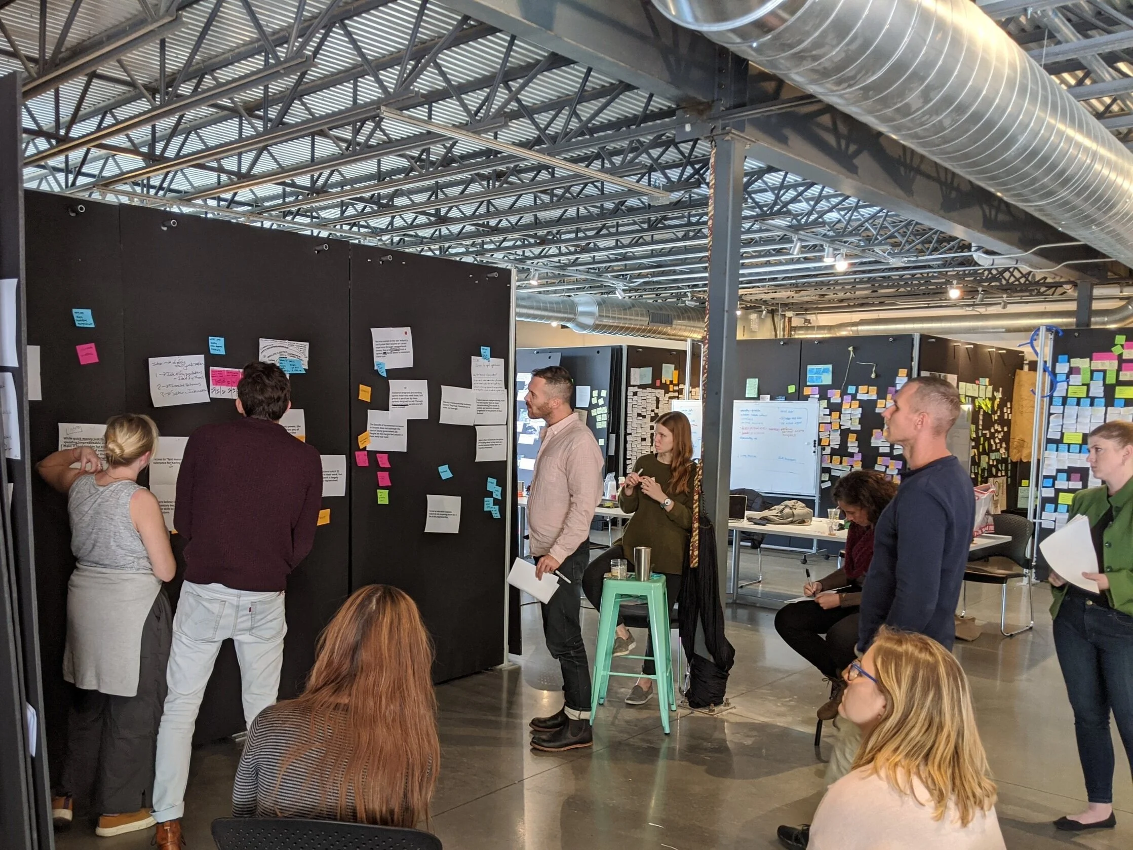 Students at Austin Center for Design critically analyzing projects displayed on foam boards.
