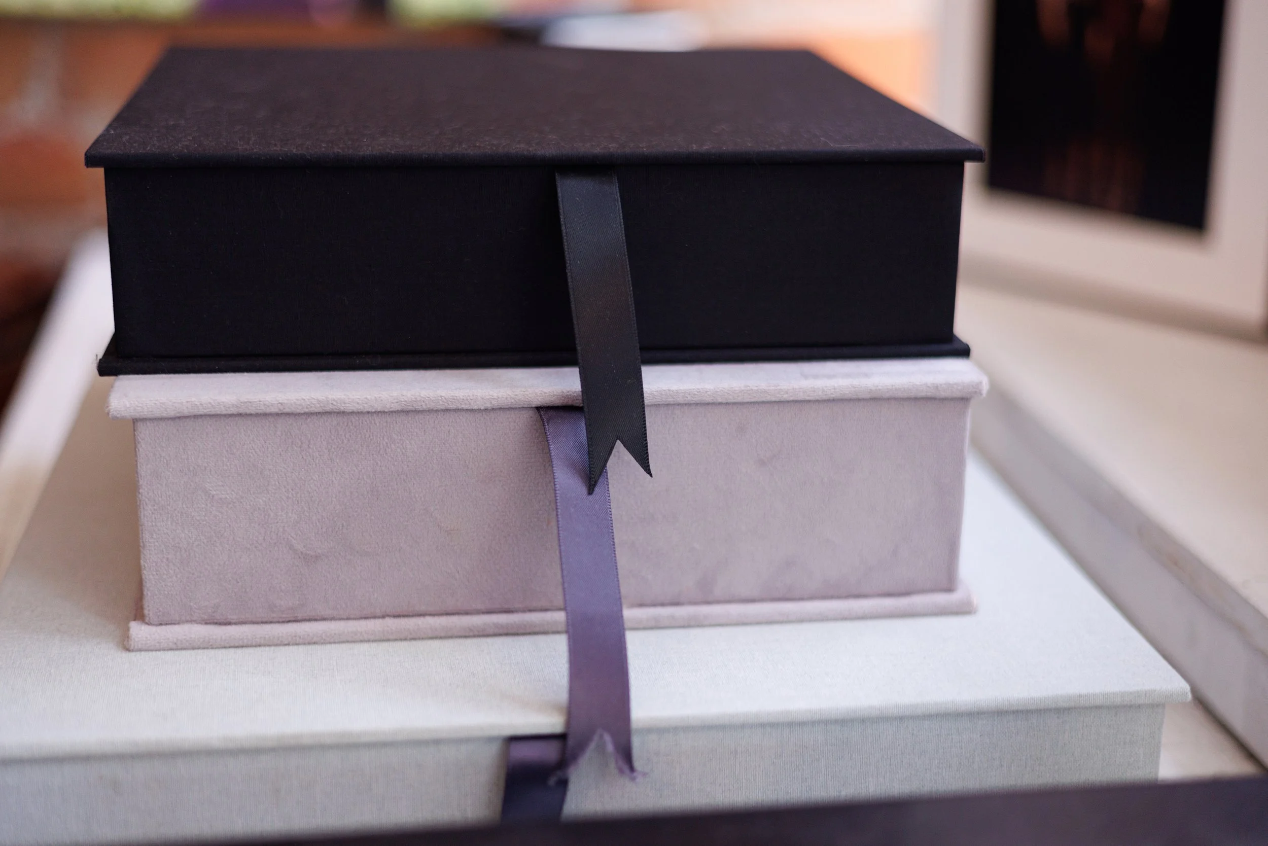 Stacked luxury portrait folio boxes and archival print boxes used for preserving fine art photography and heirloom portrait collections