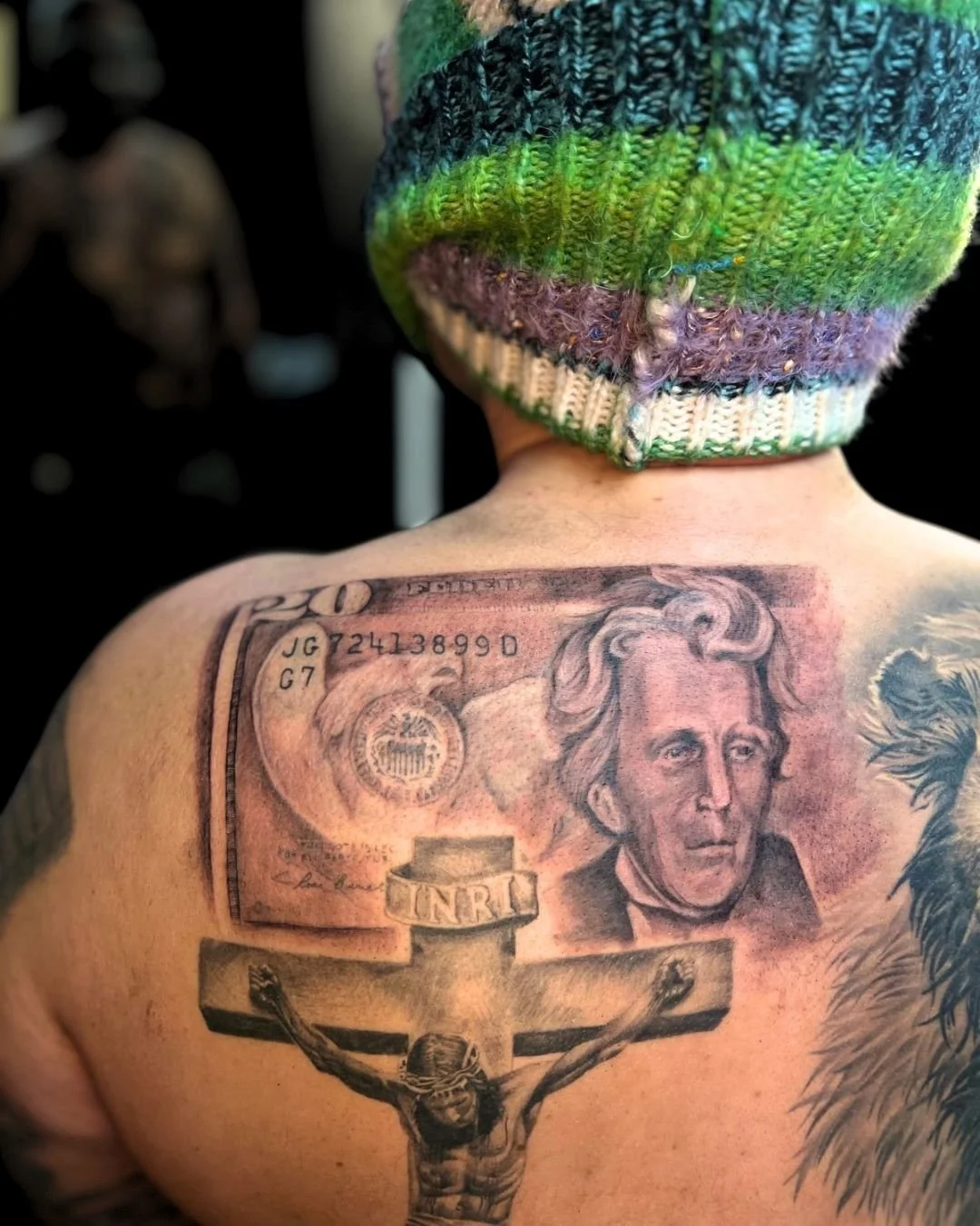 This black and grey realism tattoo features a detailed currency-inspired portrait rendered with smooth shading, fine linework, and lifelike texture. The design emphasizes depth, contrast, and realism, creating the appearance of engraved currency artw