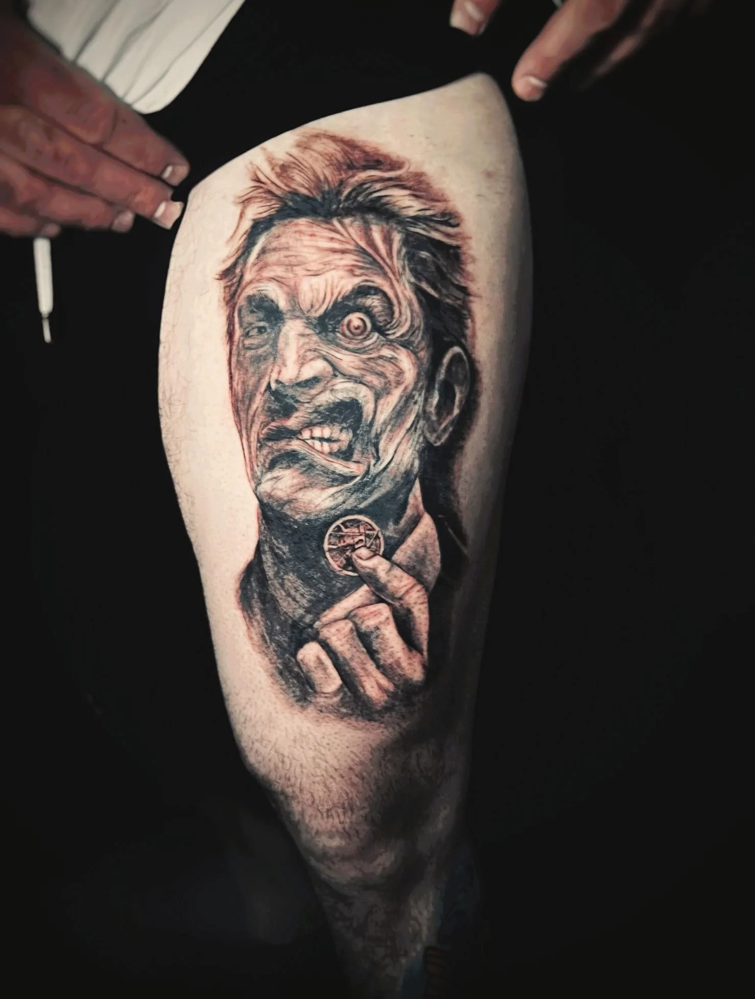 Black and grey horror portrait tattoo on calf featuring an intense, realistic facial expression, created at a professional Bronx tattoo studio in NYC.