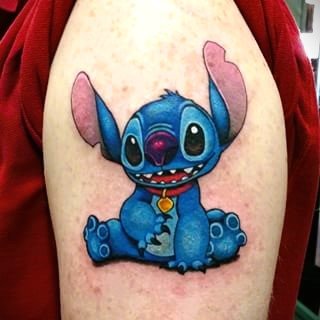 Color realism tattoo of cute blue Stitch character sitting with big years and detailed shading on skin in Bronx NYC studio