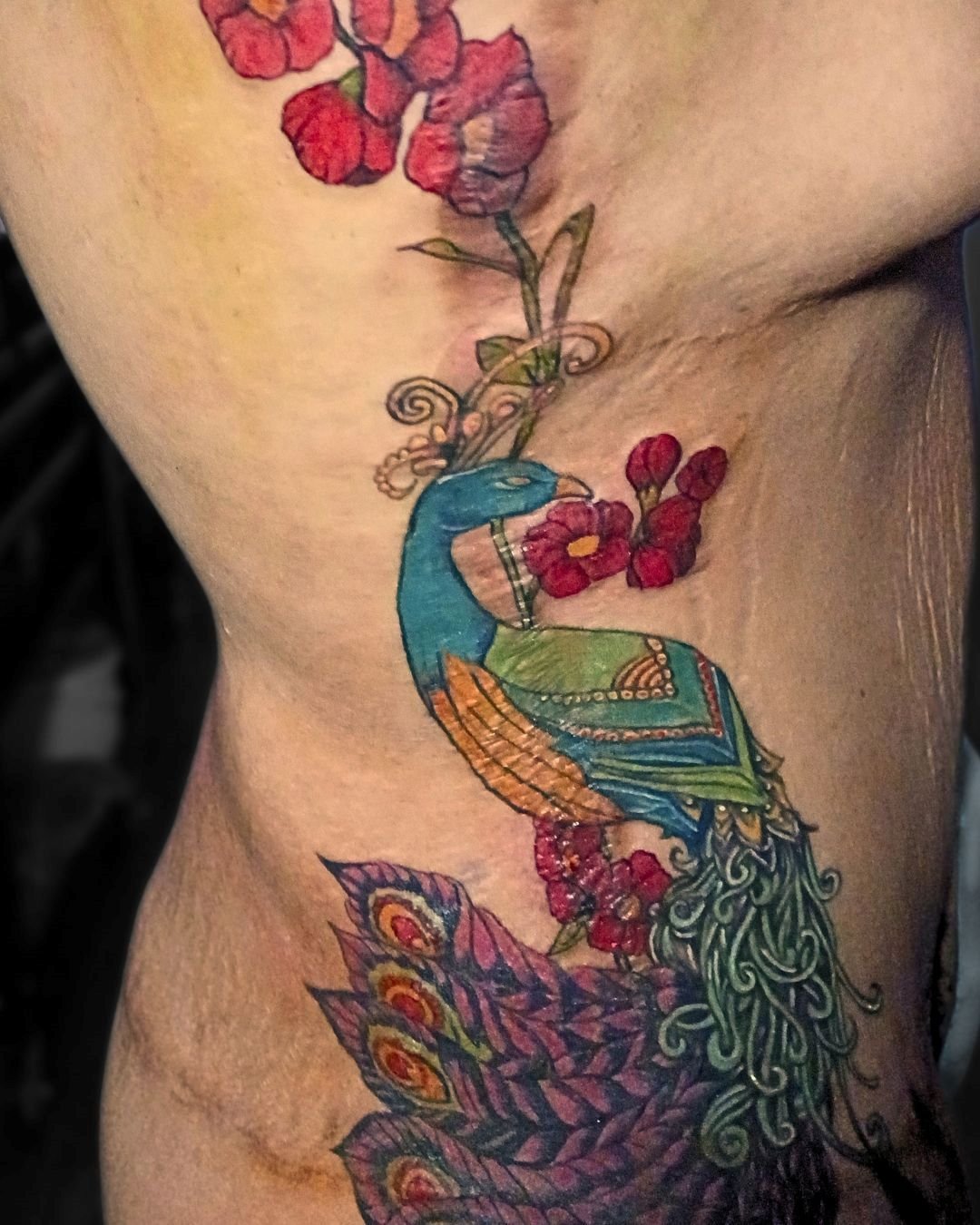 Peacock scar camouflage tattoo by Brass Knuckles Ink. Expert color scar cover-up tattoos in a clean, private studio