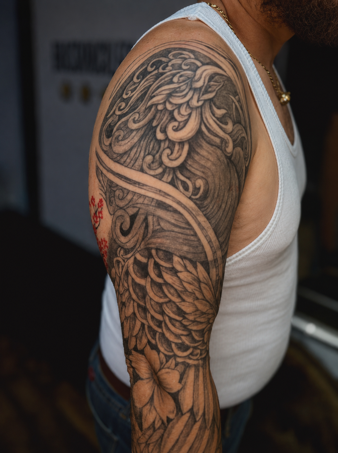 Japanese-inspired phoenix sleeve tattoo in progress featuring detailed feathers, flowing wind bars, and black and grey shading. Custom large-scale tattoo photographed at Brass Knuckles Ink Tattoo Studio in the Bronx, NYC. Symbolizing rebirth, resilie