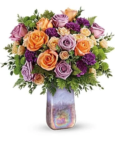 Sympathy Amethyst Sunrise BouquetTwo gifts in one! This glorious bouquet of lavender and peach roses is arranged in a hand-blown art glass vase.Starting at $114.95