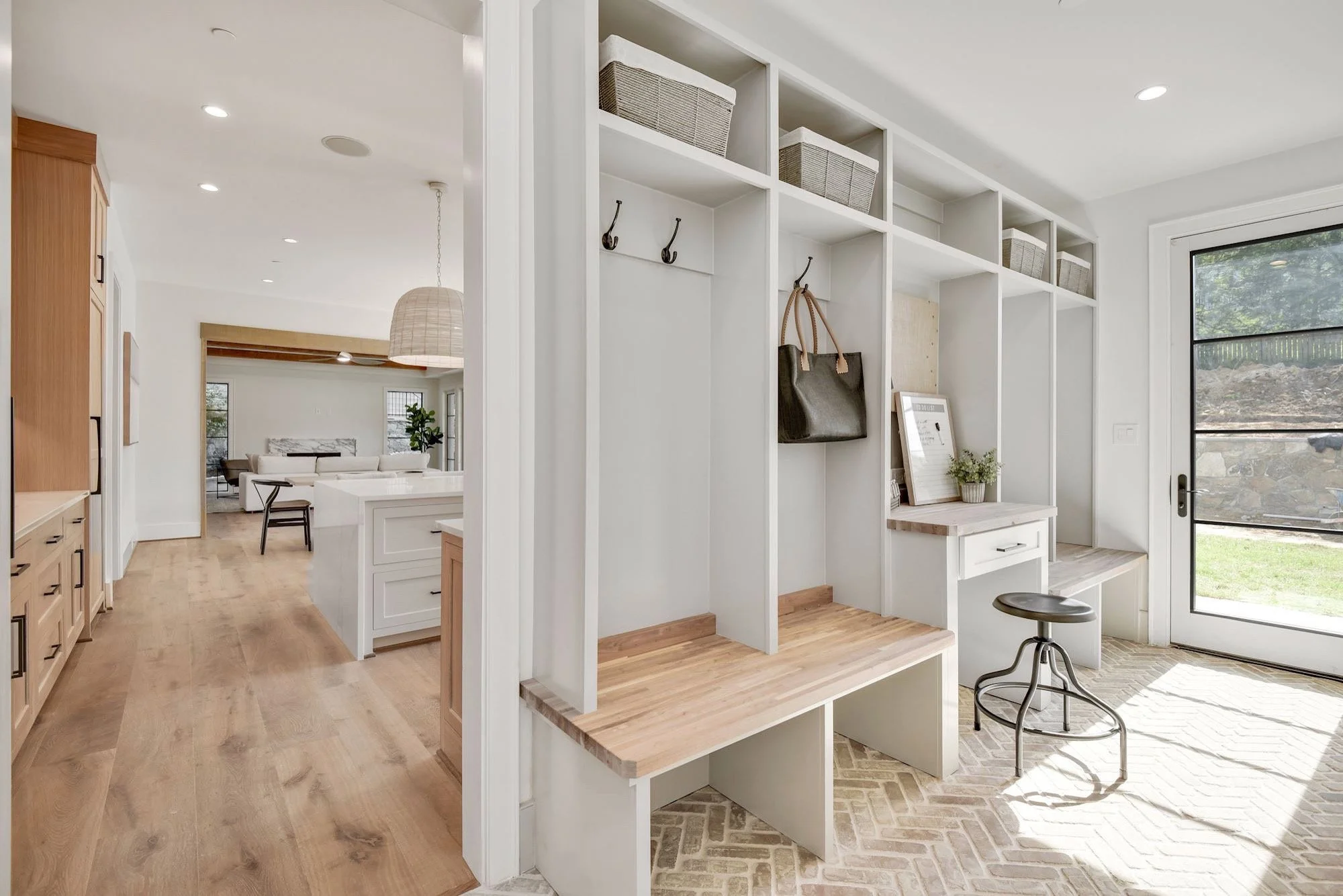 Bright kitchen and mudroom with custom storage, white cabinetry, and natural wood accents.