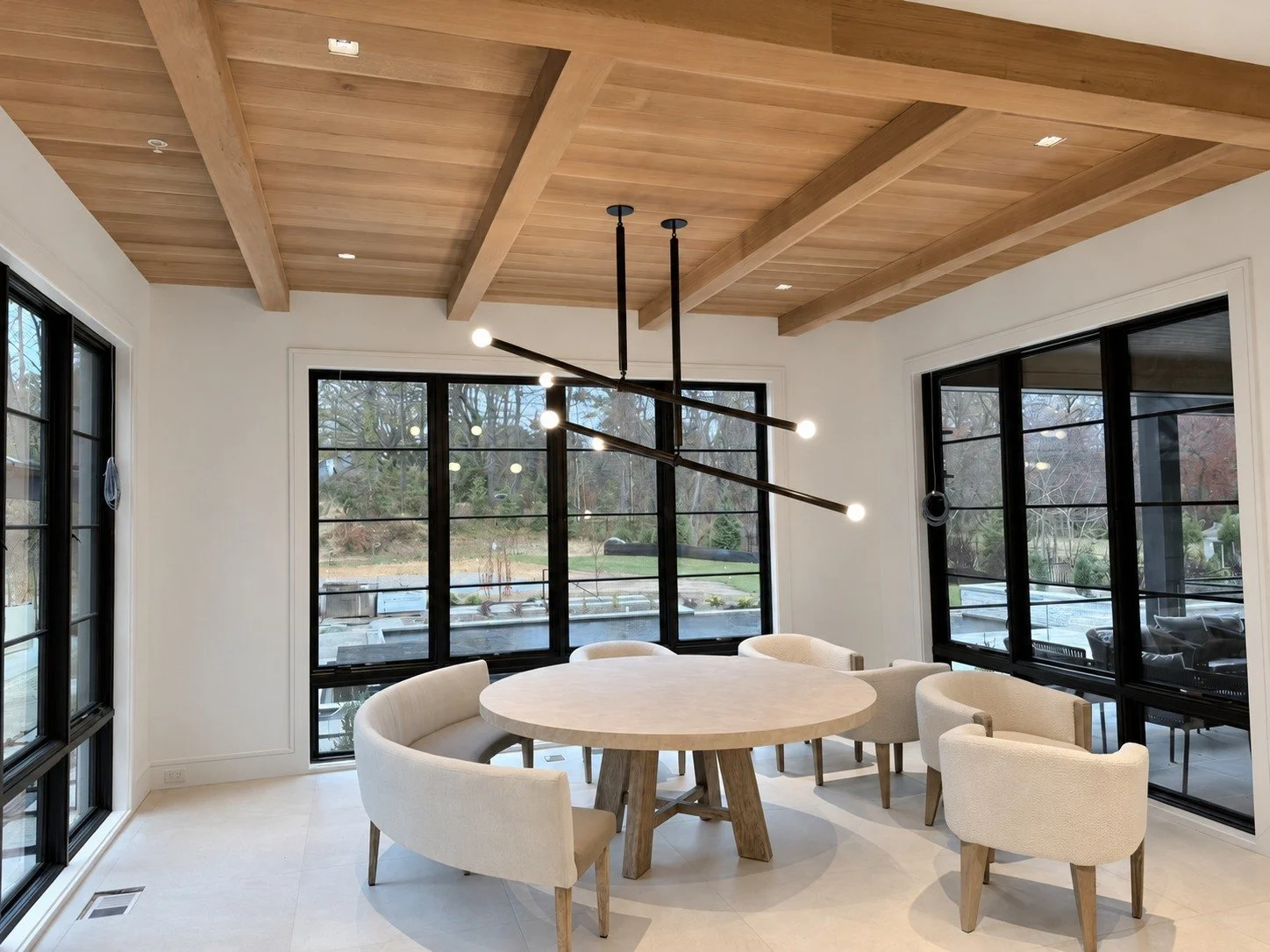 Warm timber ceiling panels and beams, carefully aligned trim and expansive glazing.