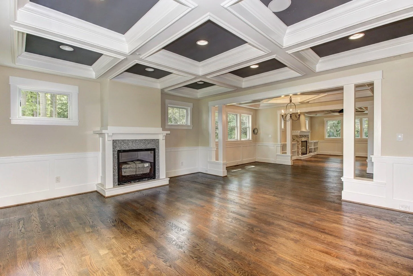 6604 Seven Locks Road: living room with coffered ceiling, custom trim, hardwood floors, and fireplace.