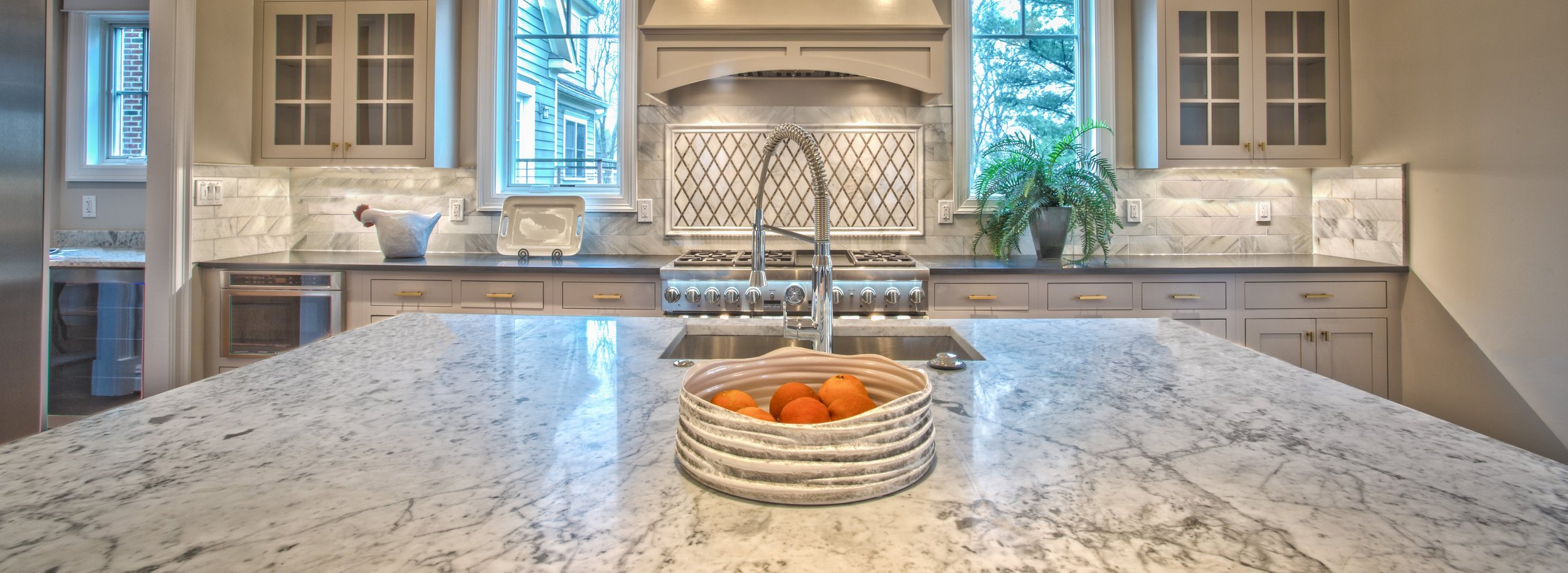A kitchen made for gathering: generous stone island, warm cabinetry and natural light.