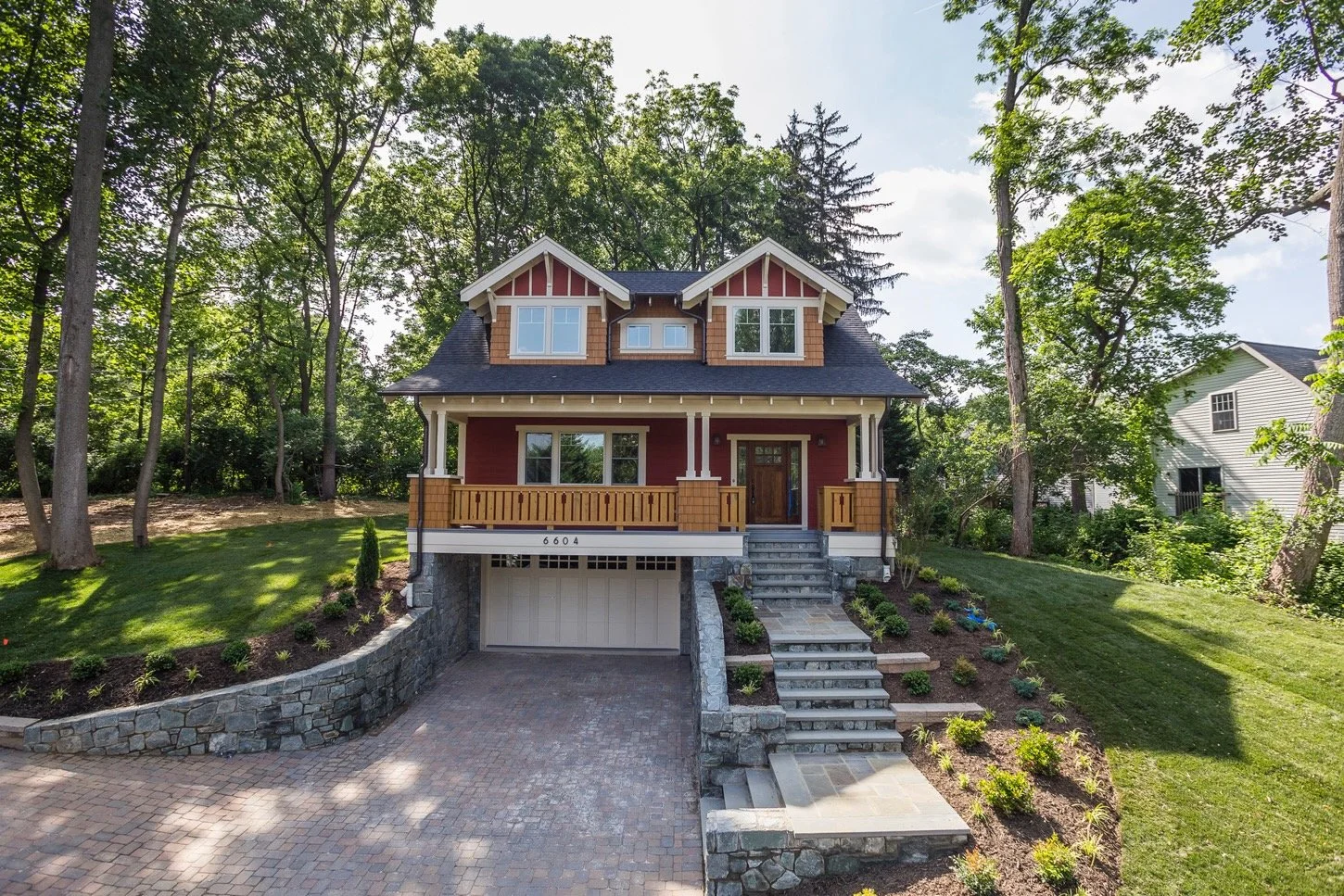 6604 Seven Locks Road: completed exterior with front porch, stone steps, and landscaped grounds.