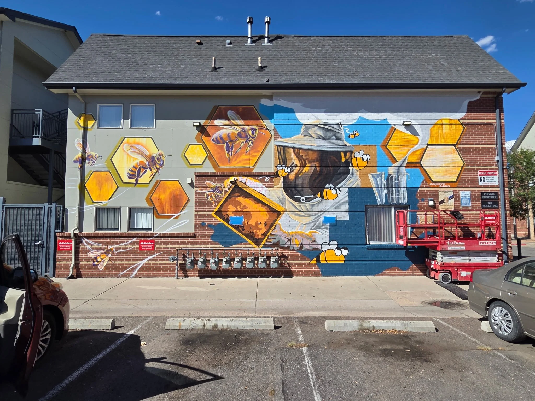 A large mural featuring bees and a beekeeper.