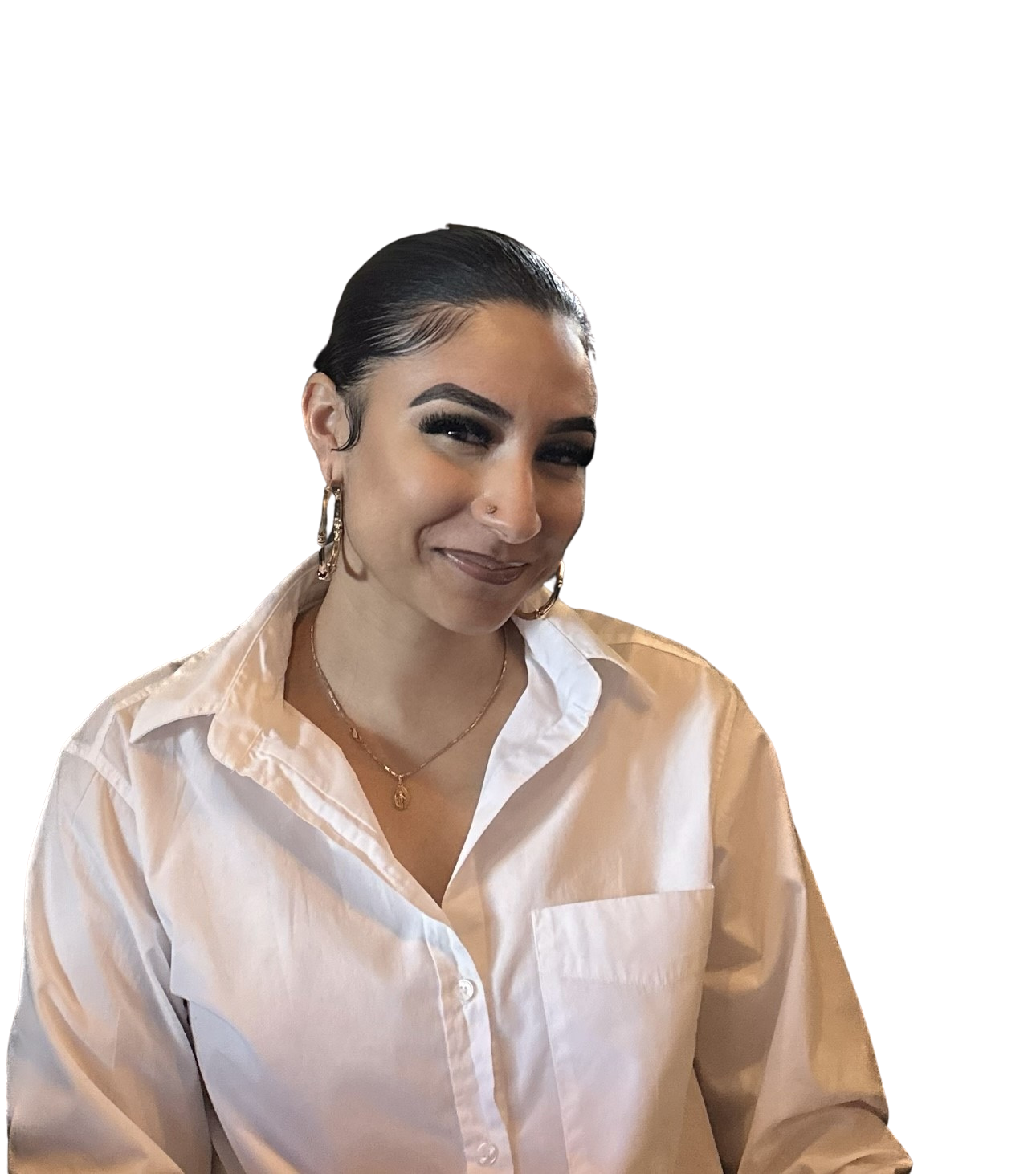 A woman with dark hair slicked back, wearing a white button-up shirt, gold hoop earrings, a gold necklace, and makeup including dark eyeliner and lipstick.