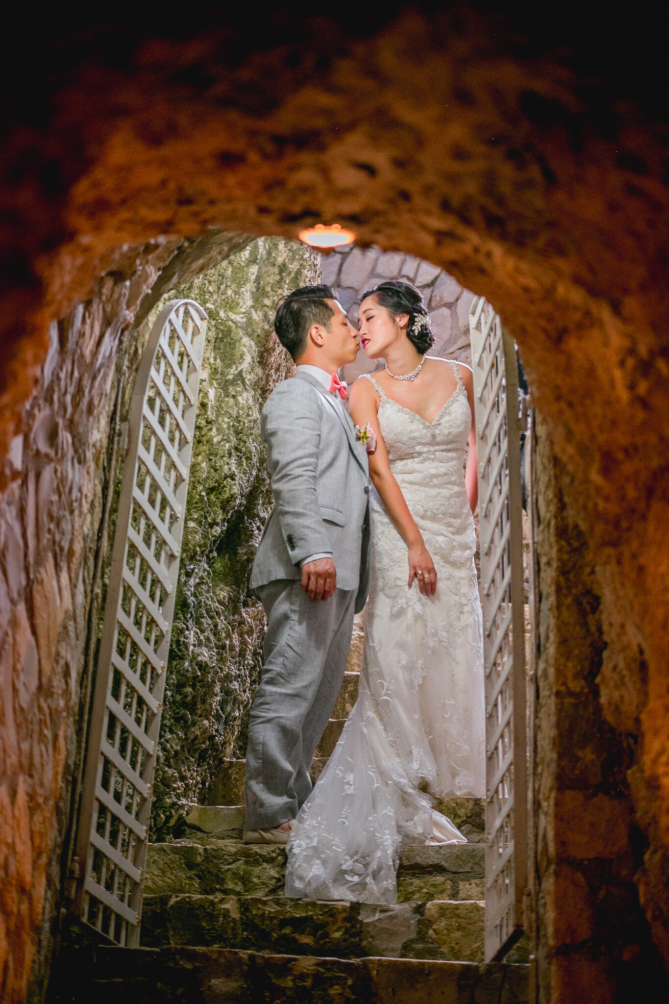 Asian couple kissing under cave, negril jamaica