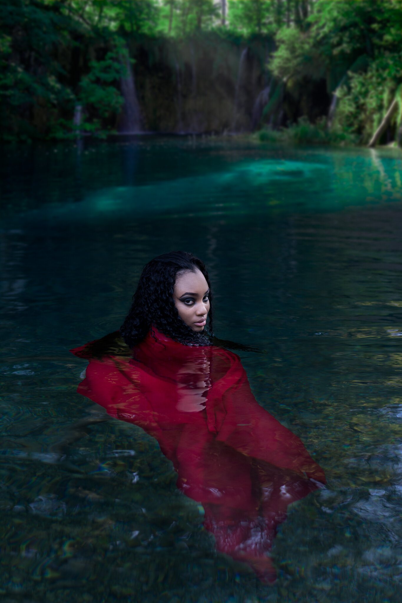 dark conceptual photoshoot in water with red dress