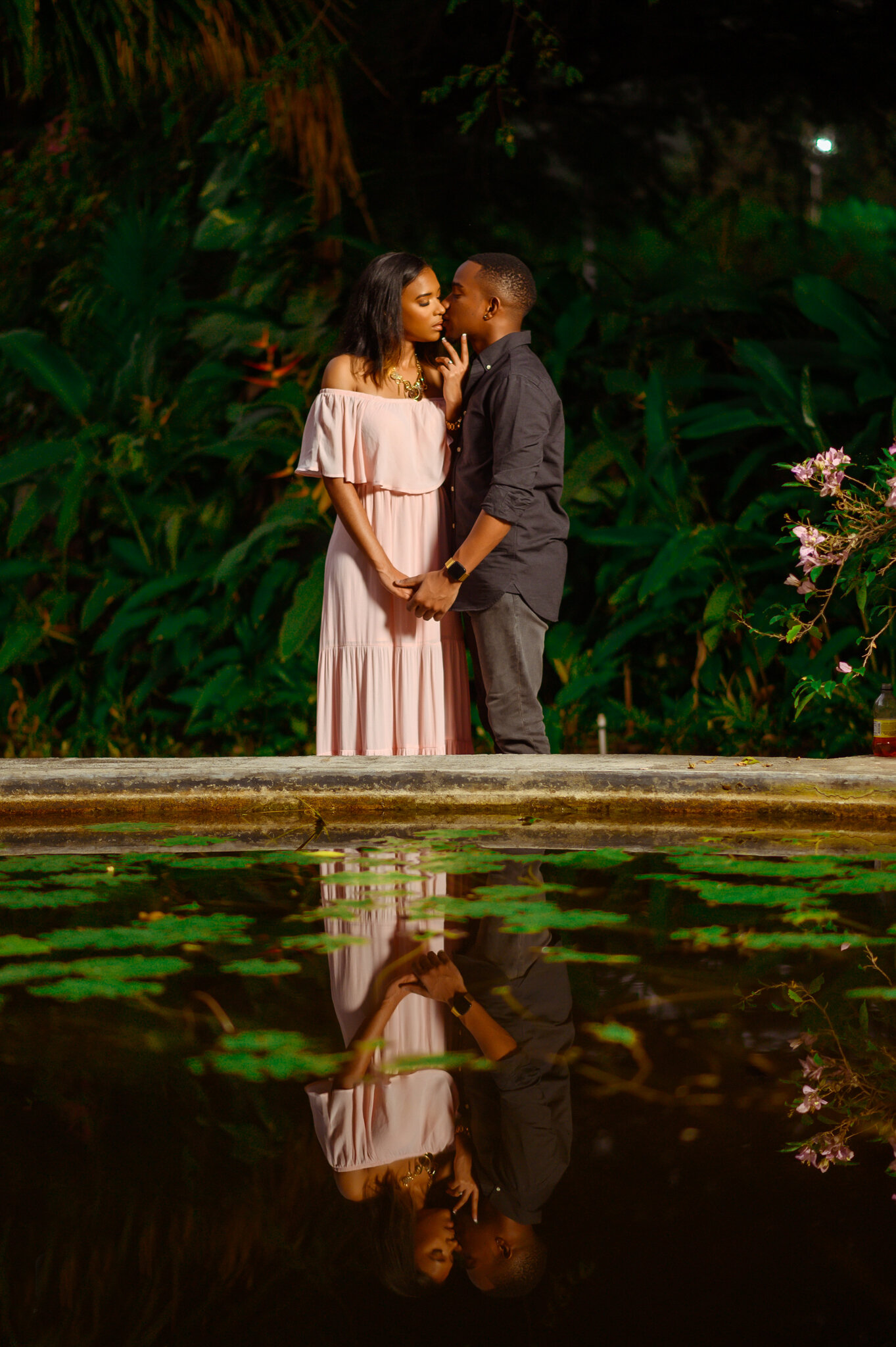 bride and groom kissing in front of pond with reflection hope gardens