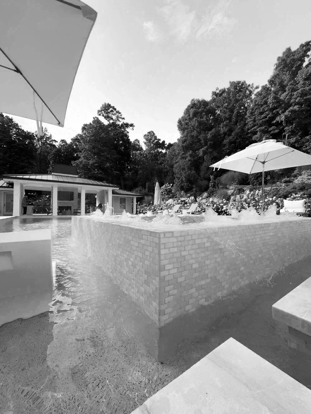 Custom gunite pool, pool house, and outdoor living environment integrating aquatic design, landscape, and architecture, representing the foundation of MESSUTI