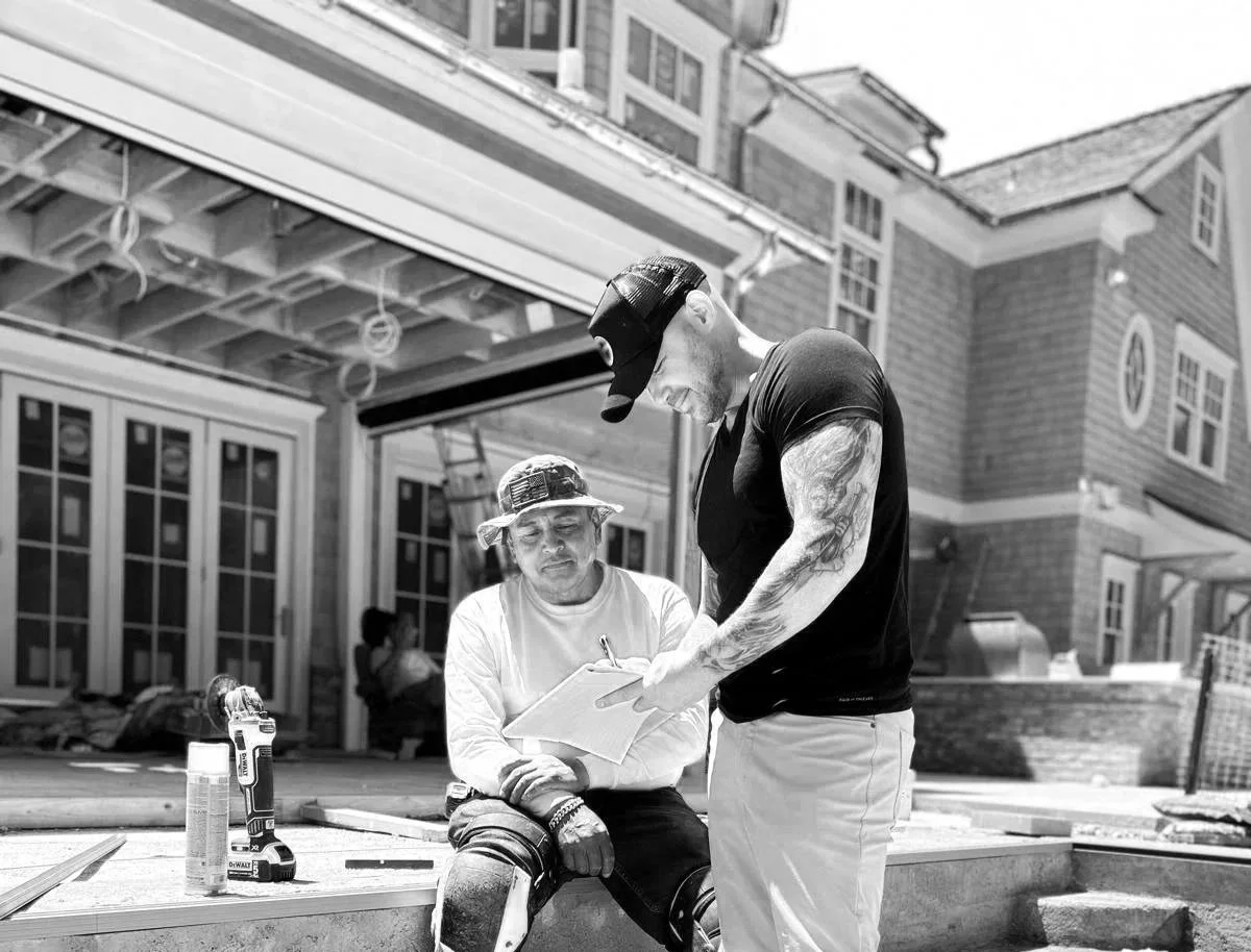 Gabriel Messuti reviewing construction details on site during a custom outdoor living and gunite pool project, illustrating the Art × Certainty™ approach alongside a master mason