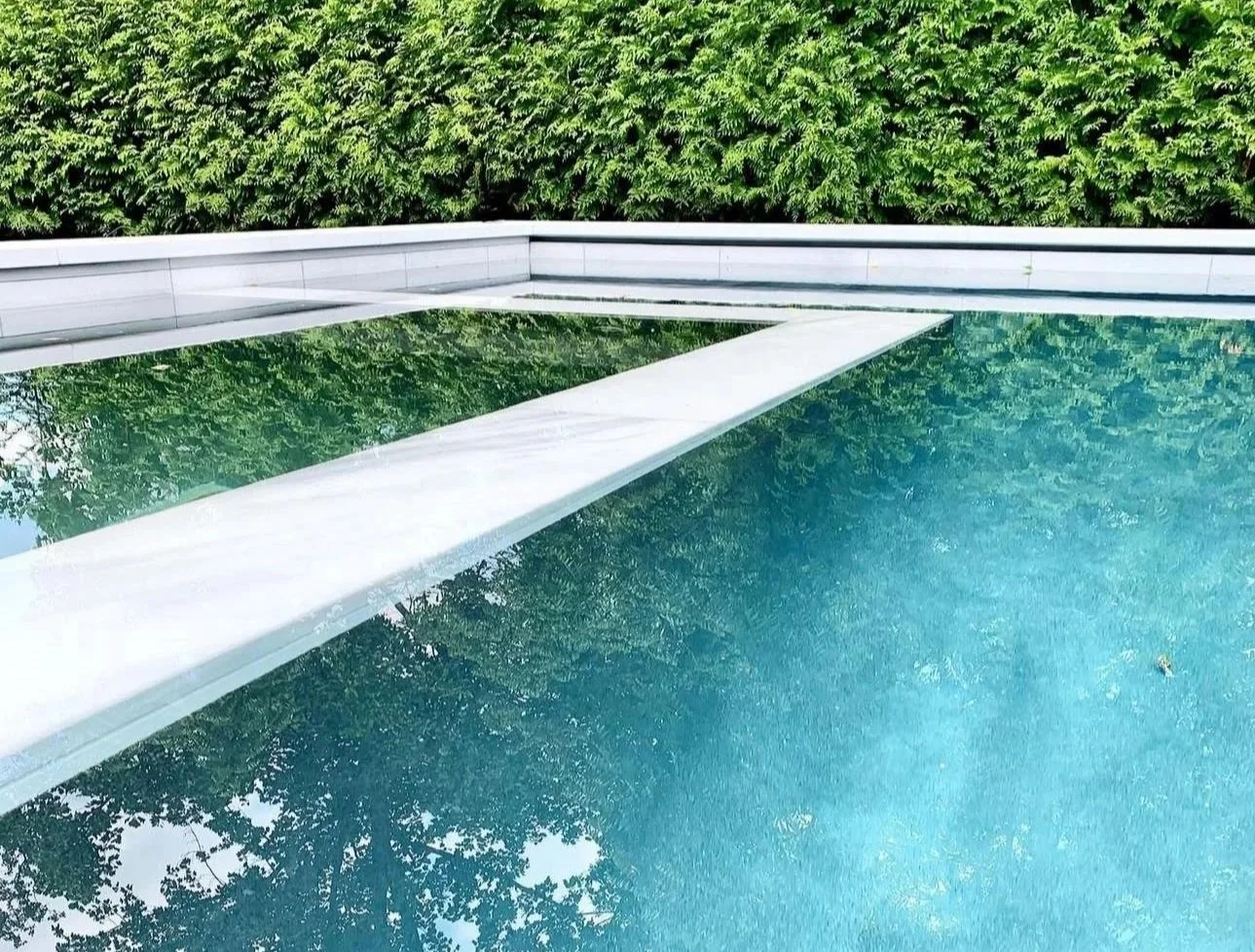 Marble pool coping with submerged marble wall detail and matching marble tile