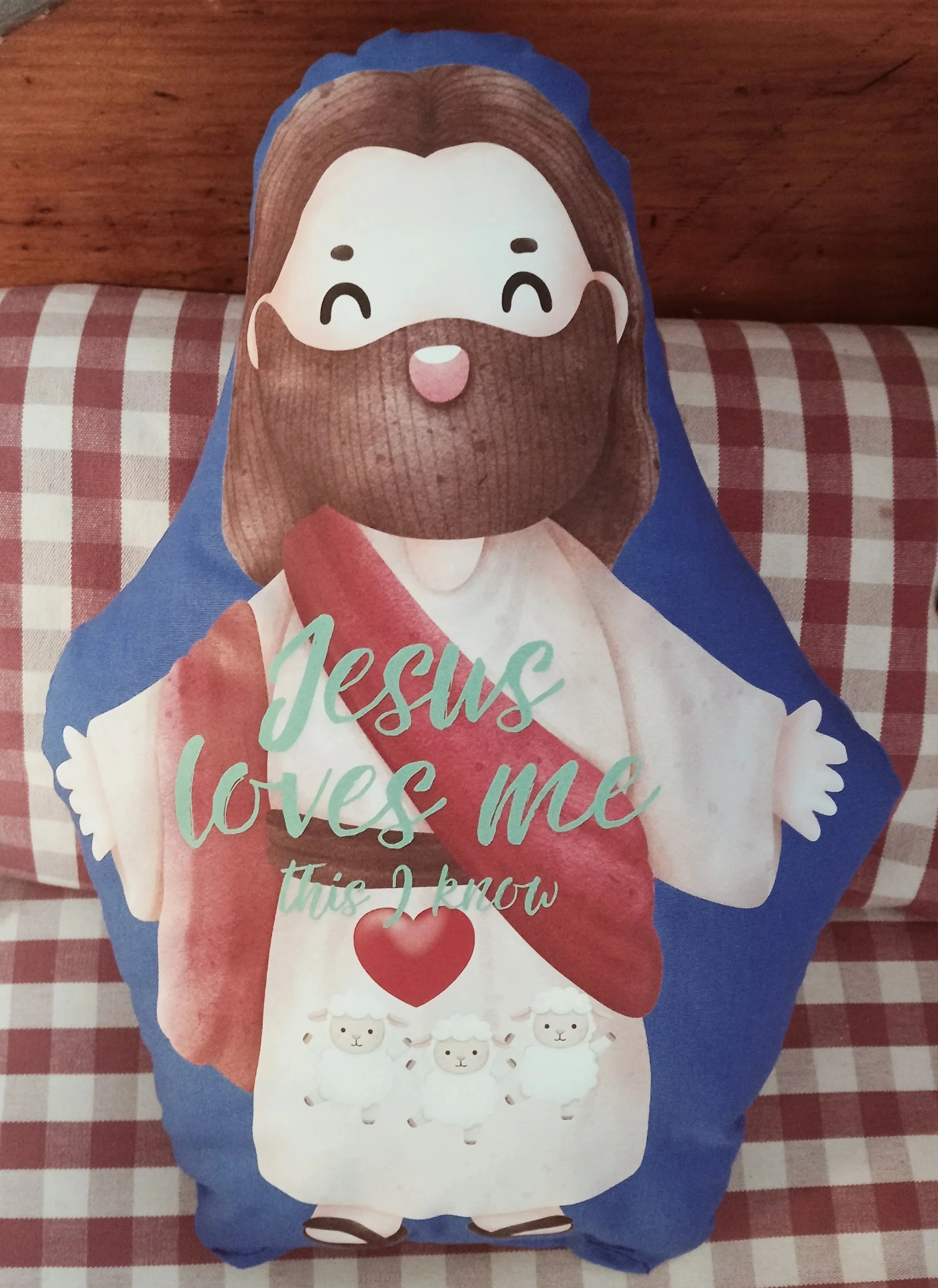 An adorable adaption of Jesus in the form of a huggable cushion. Comes with the phrase ‘Jesus loves Me This I know’ and three baby lamb’s on His lap.