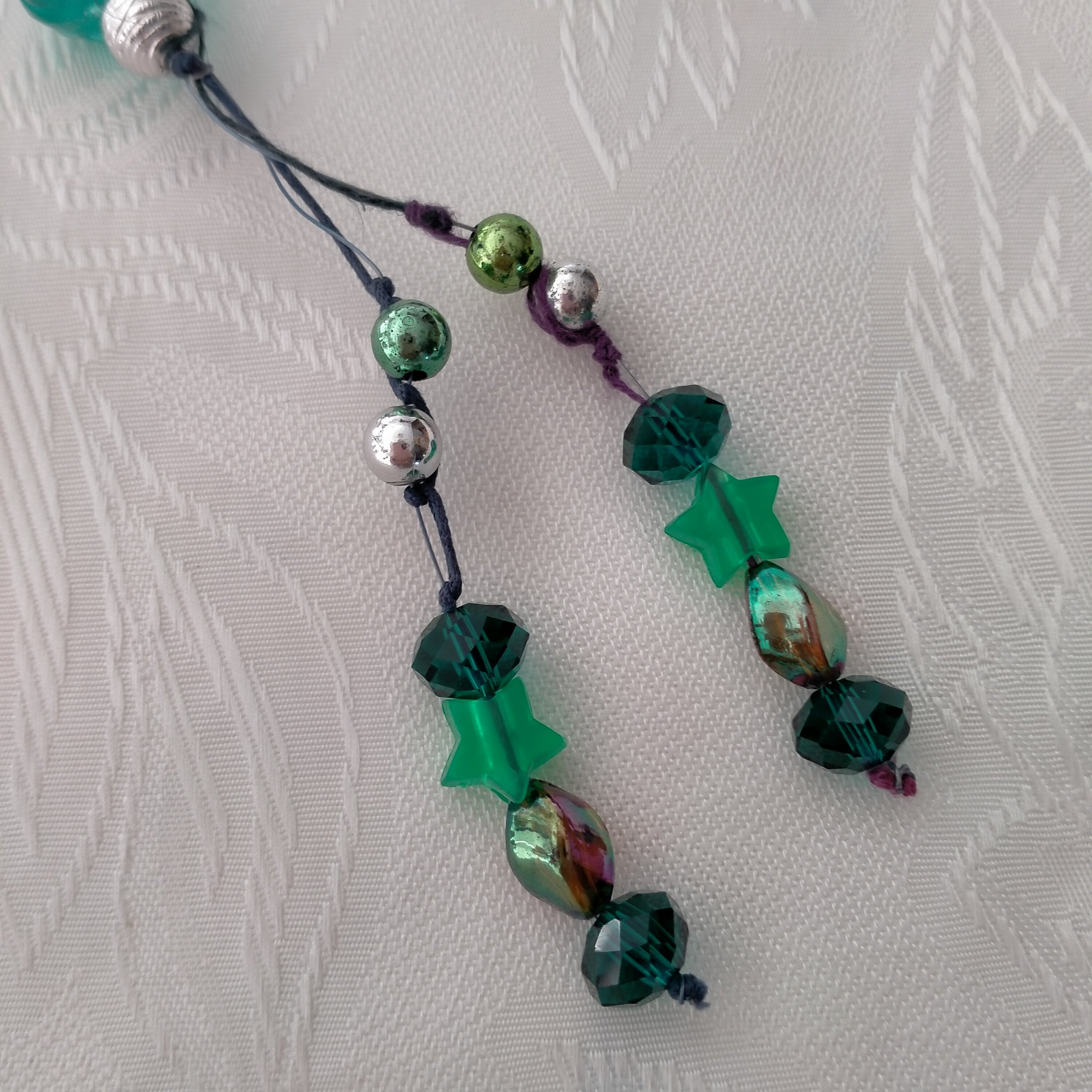 A beautiful necklace made using glass, crystal, acrylic, metal, resin and plastic beading. Several shades of greens with Crystal Rhinestones, Rondelle beads with Roses and Acrylic Stars
