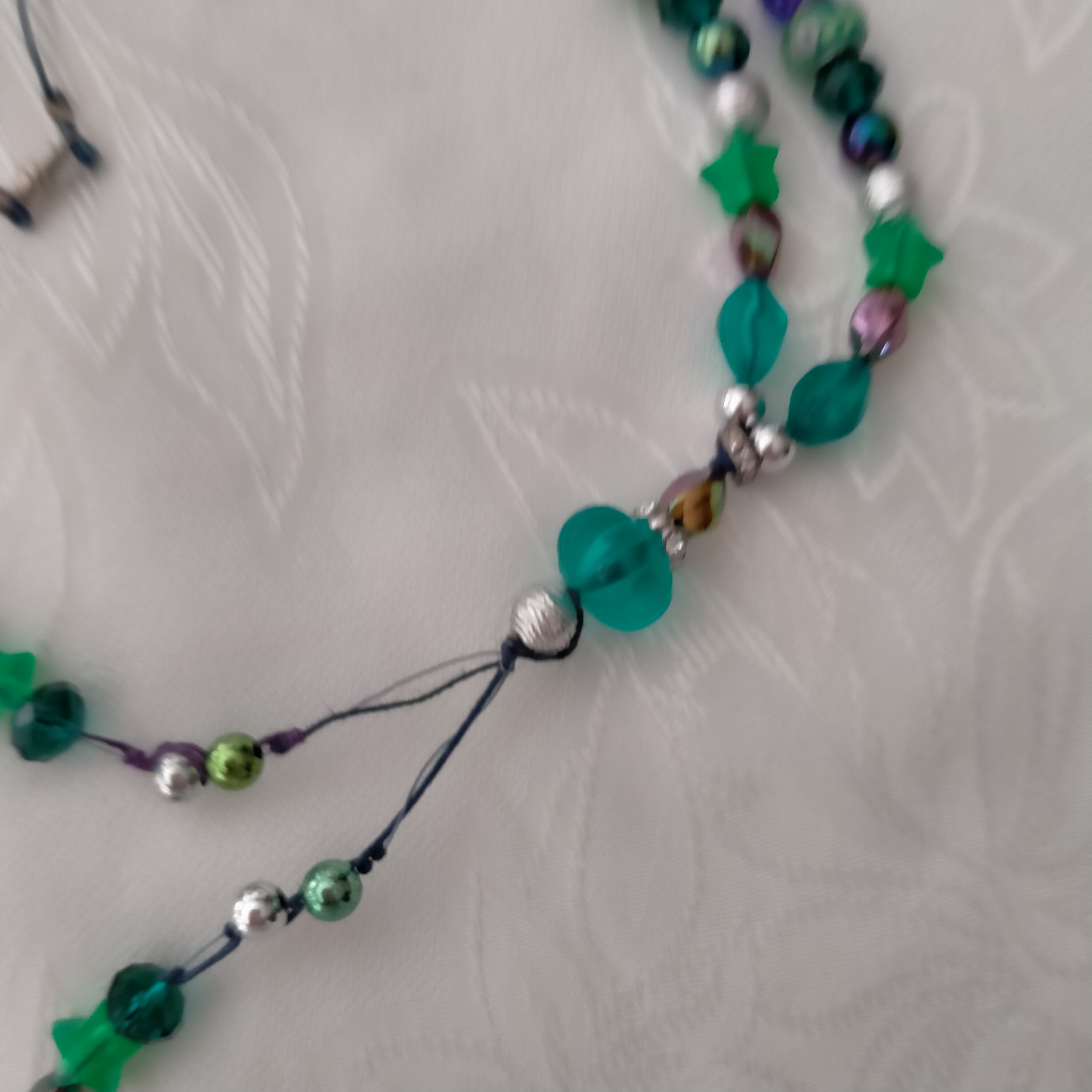A beautiful necklace made using glass, crystal, acrylic, metal, resin and plastic beading. Several shades of greens with Crystal Rhinestones, Rondelle beads with Roses and Acrylic Stars