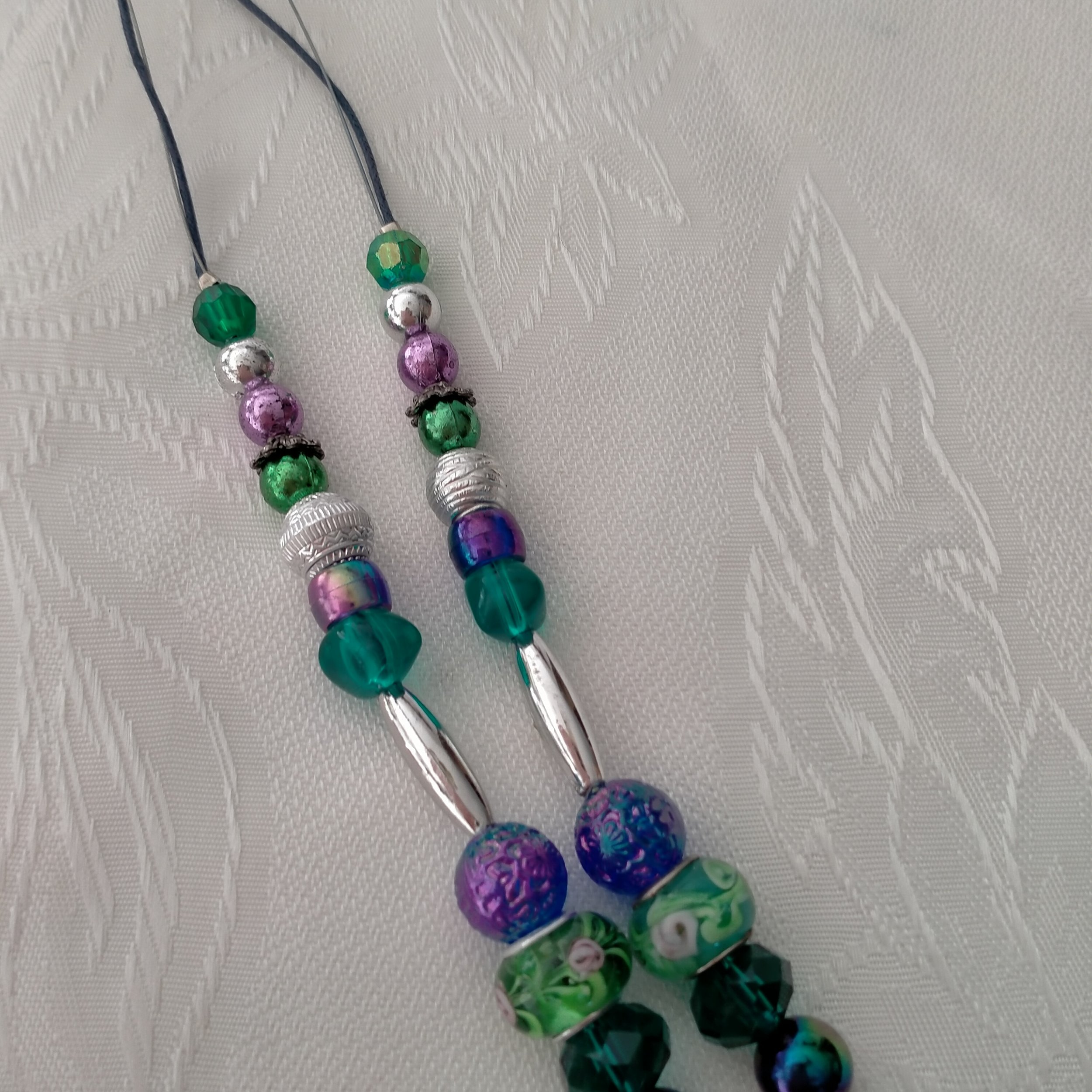 A beautiful necklace made using glass, crystal, acrylic, metal, resin and plastic beading. Several shades of greens with Crystal Rhinestones, Rondelle beads with Roses and Acrylic Stars