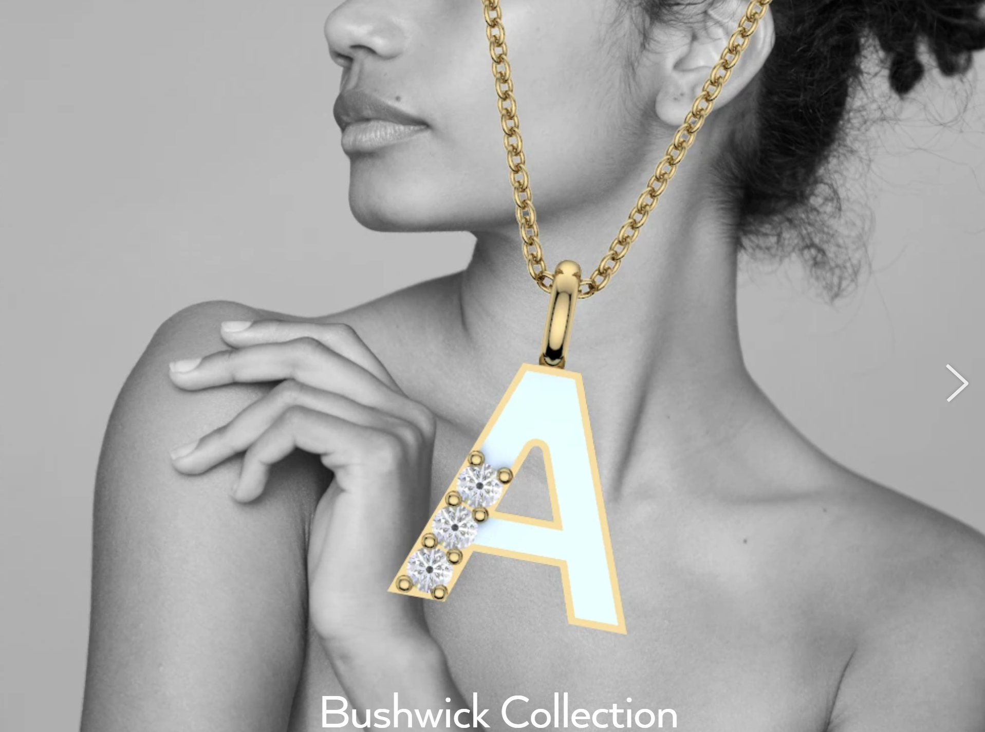 A woman with curly hair is shown in black and white, wearing a large gold chain necklace with a pendant in the shape of a letter 'A' adorned with rhinestones or diamonds.