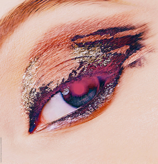 Close-up of a person's eye with vibrant eyeshadow and glitter makeup.