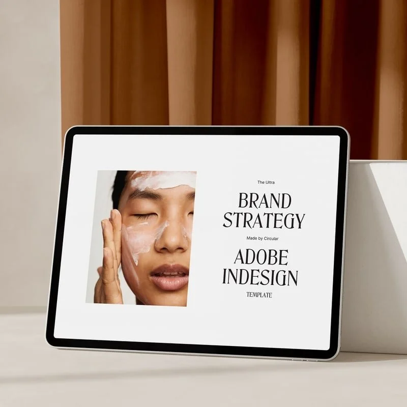 Tablet displaying a skincare advertisement with a woman applying cream and text about brand strategy and Adobe InDesign template.
