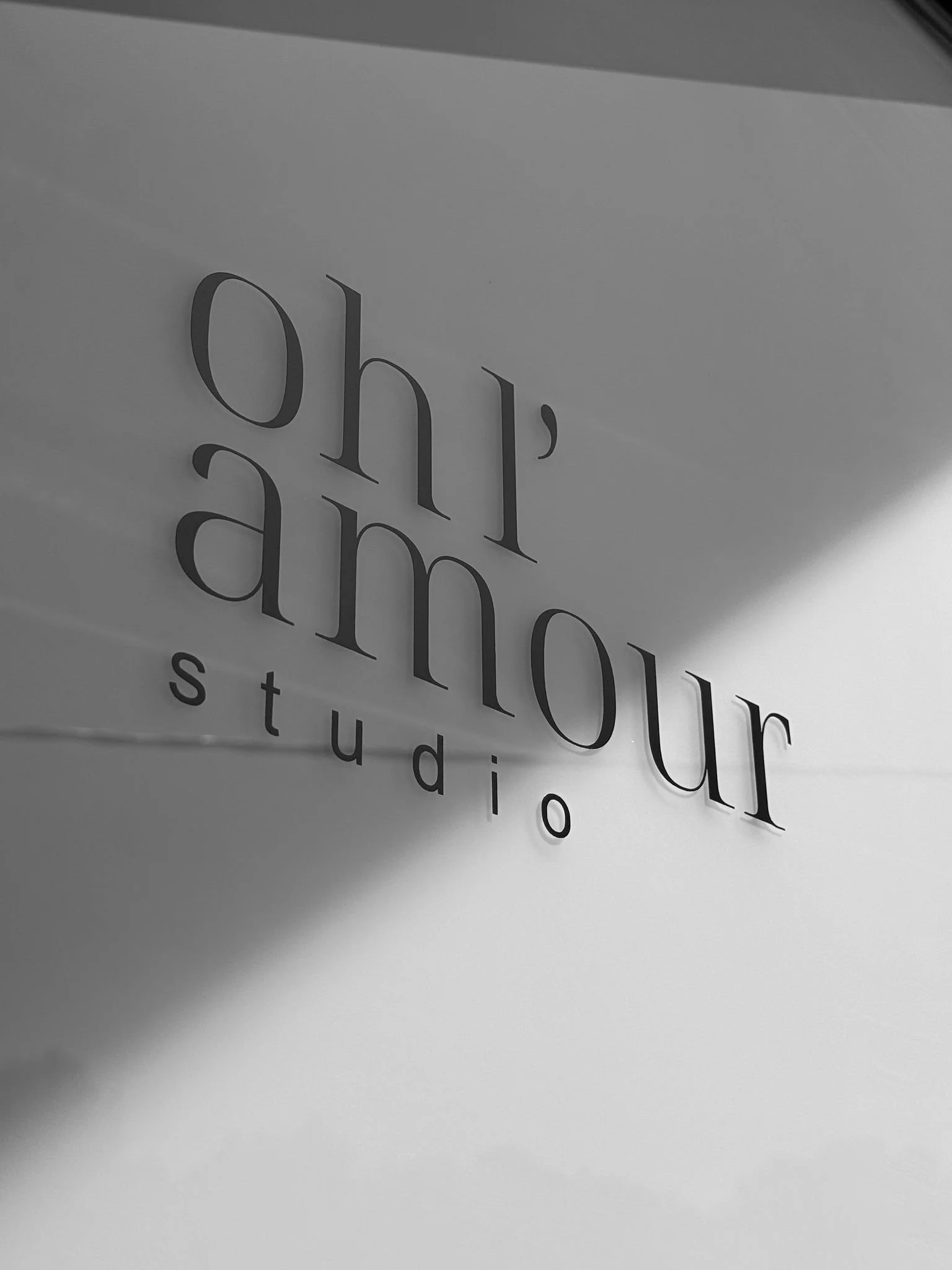Close-up of a sign reading 'oh,our studio' in black letters on a light background.