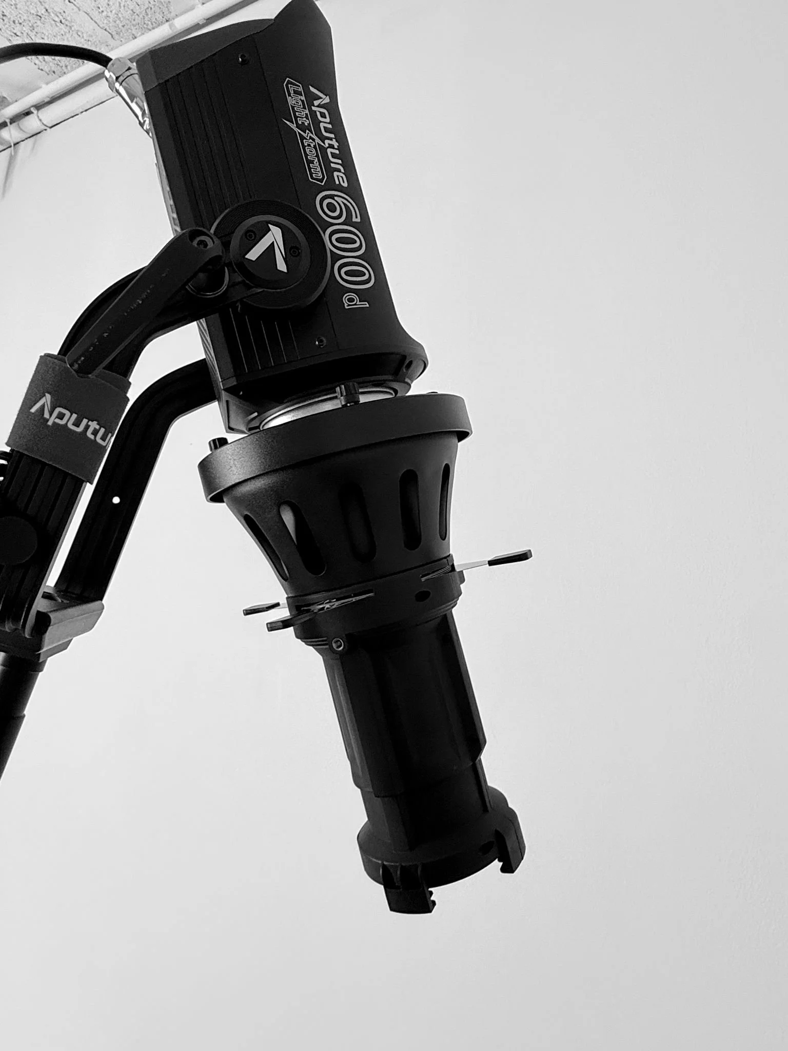Close-up of a black Apoutur branded camera gimbal or stabilizer showing the arm and motor components against a plain light gray background.