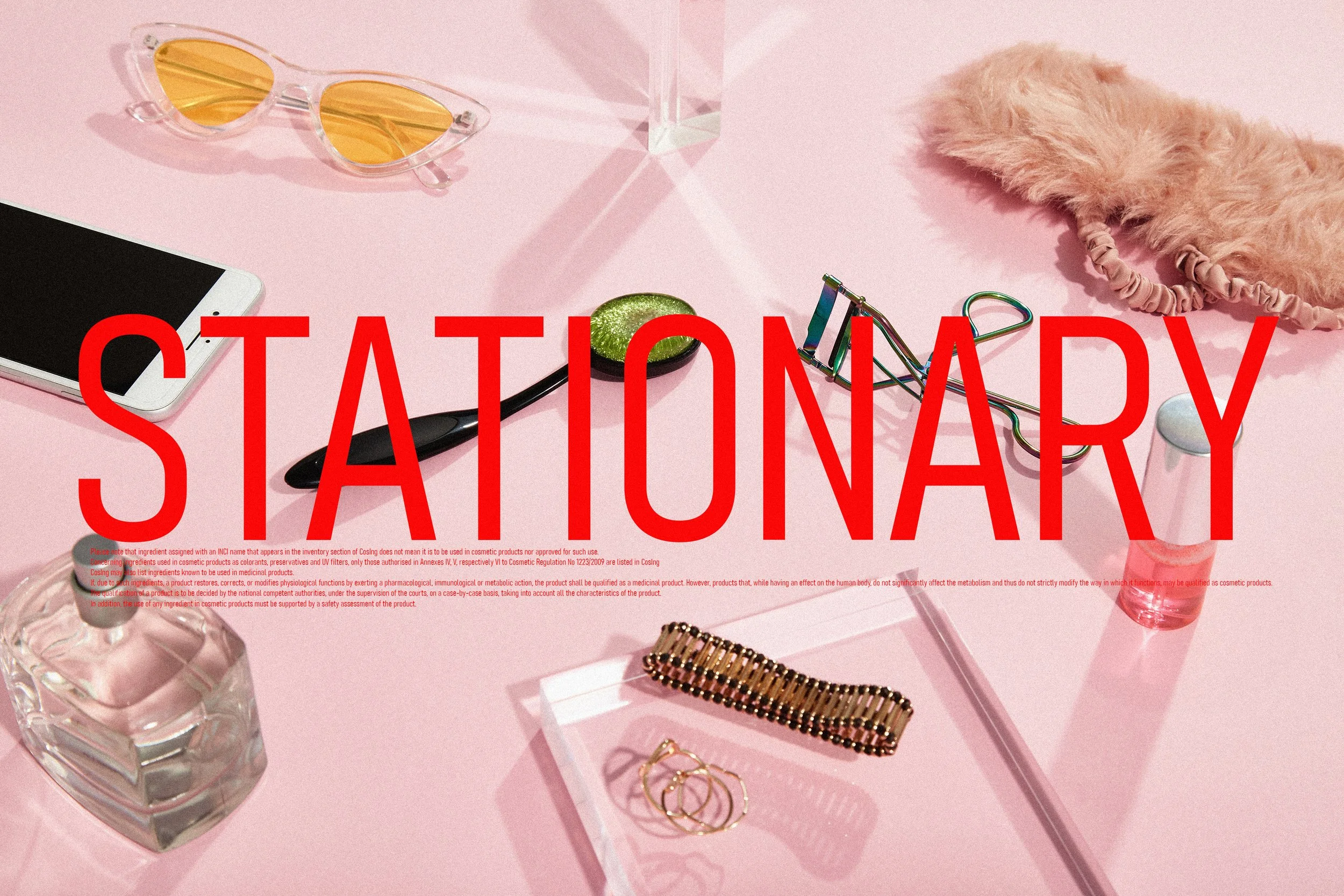 Flat lay of various fashion accessories and beauty products on a pink background, including sunglasses with yellow lenses, a smartphone, a lip gloss, gold jewelry, a hair scrunchie, and a pair of eyelash curlers, with a large red caption that reads '