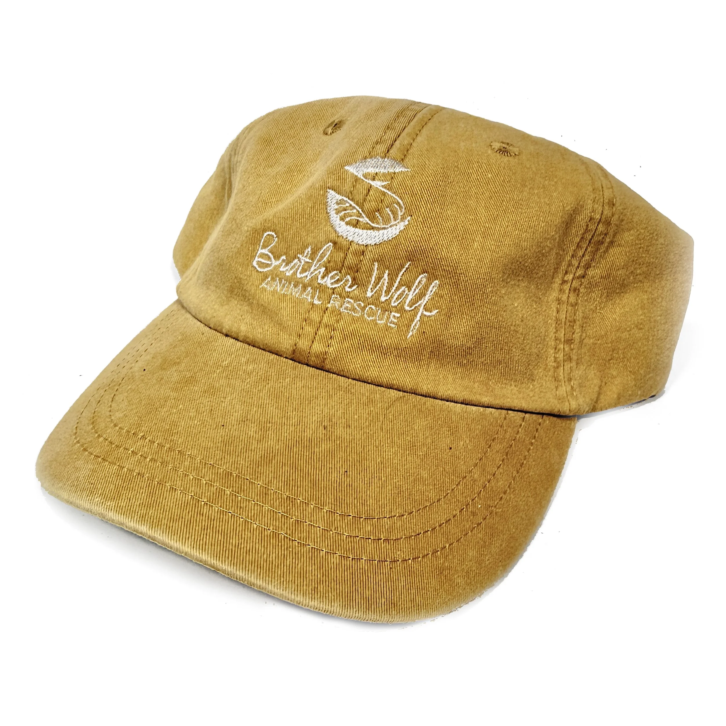 A mustard colored baseball cap with white embroidered text reading "Brother Wolf" and a logo.