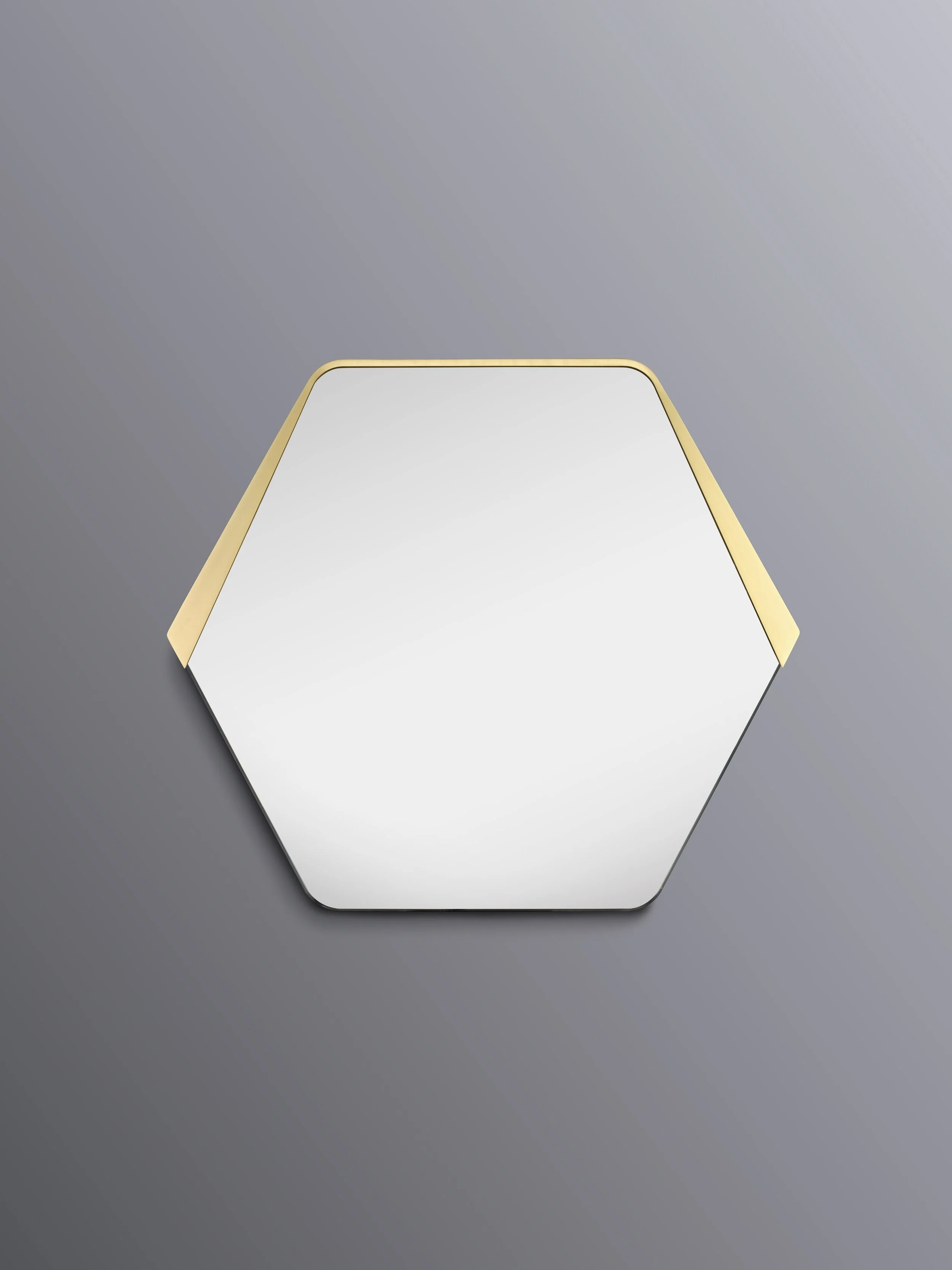 Strata Mirror by Jake Oliveira Studio featuring a geometric starphire-glass face with chamfer detail and sculptural brass frame.