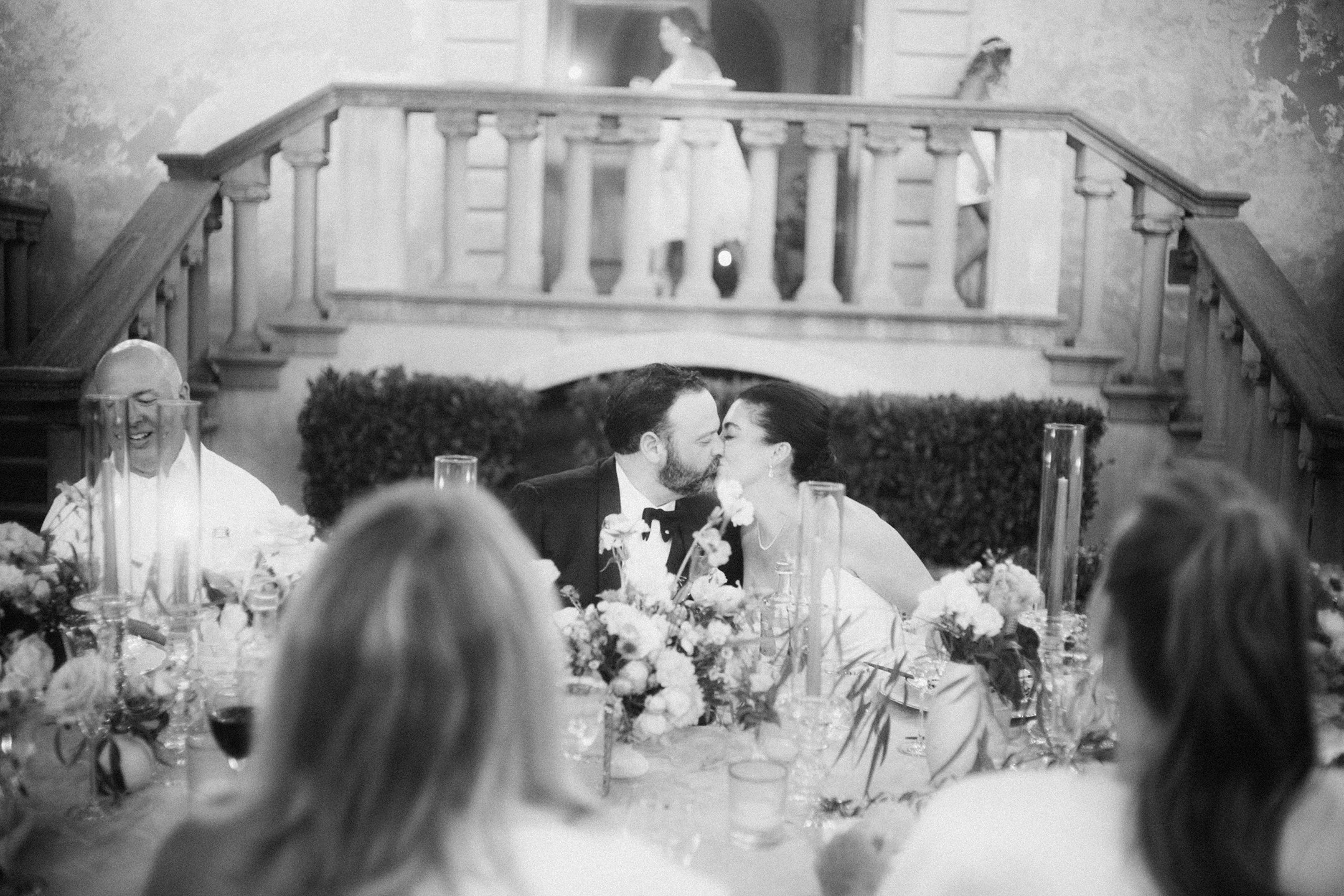 Bride and groom kissing during an emotional moment during their al fresco dinner reception at Villa Mangiacane in Tuscany Italy.