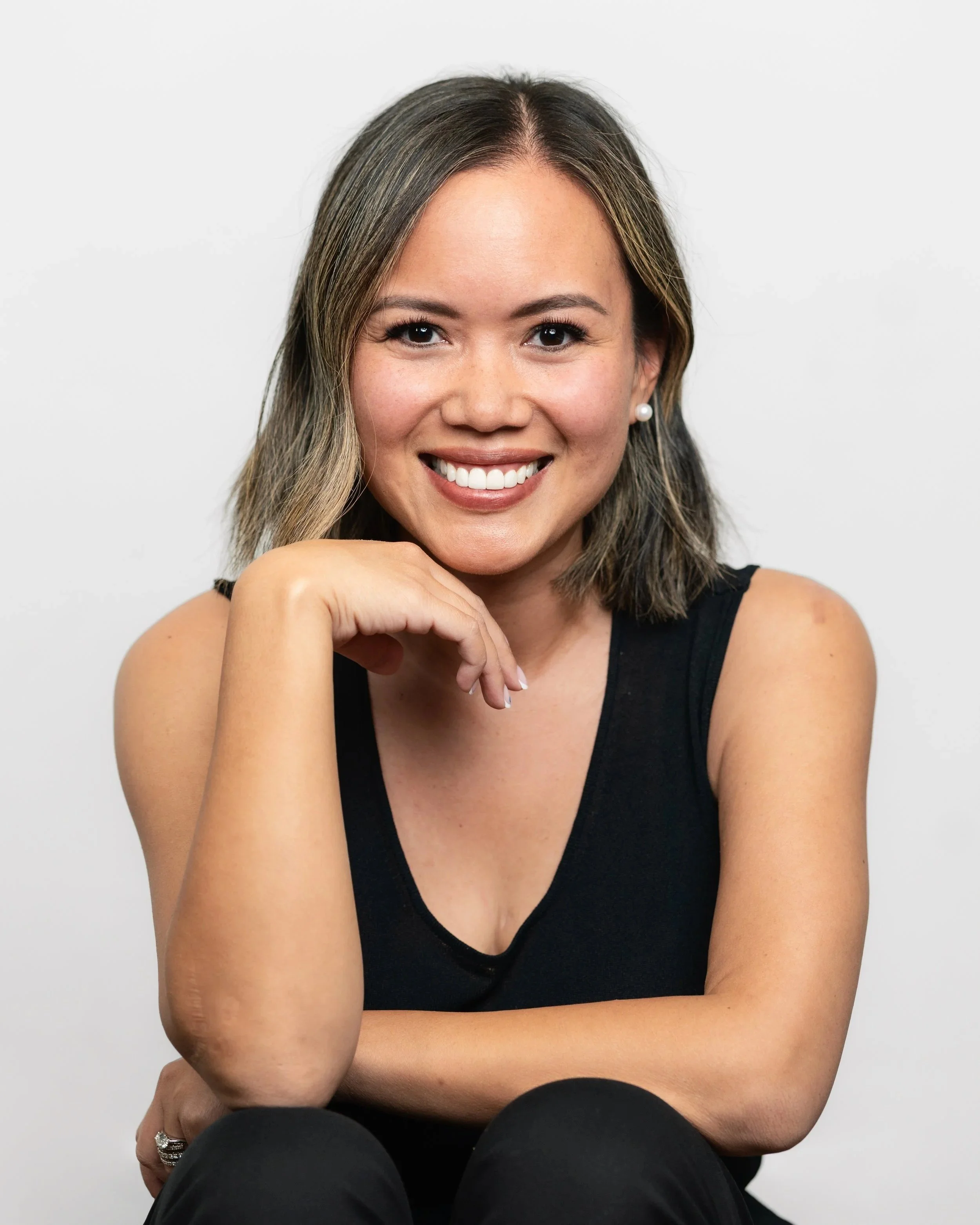 Seattle area studio portrait headshot session. Woman in black outfit with blank background. Professional photos for website, LinkedIn, and profile pictures. Professional posing and editing.