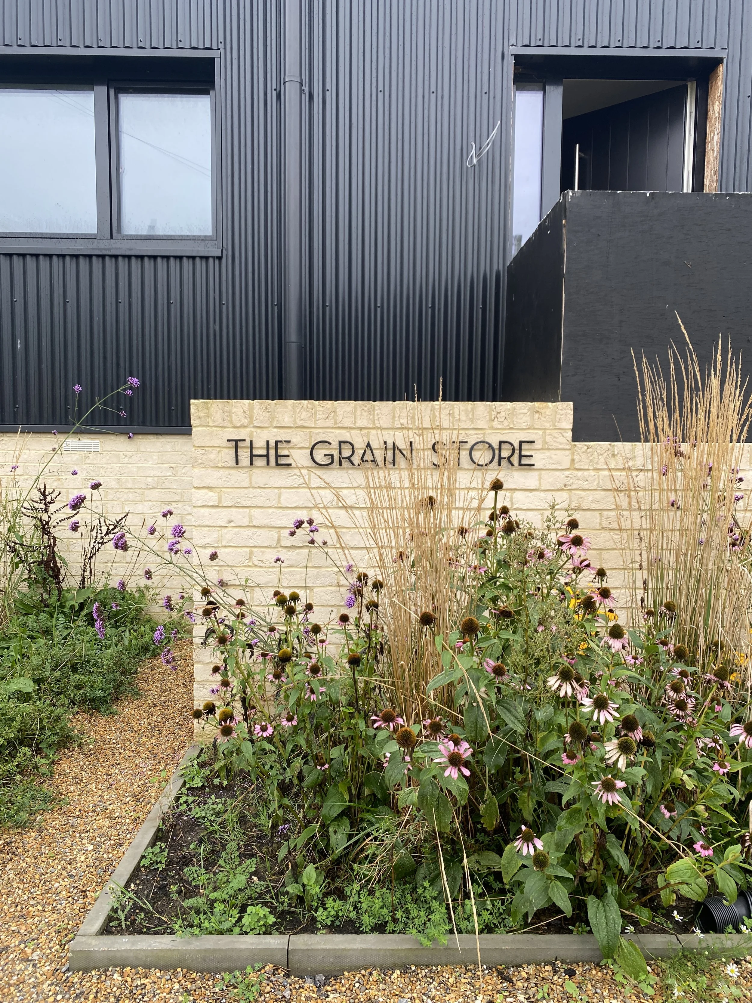 The grain store metal house sign on brickwork.JPG