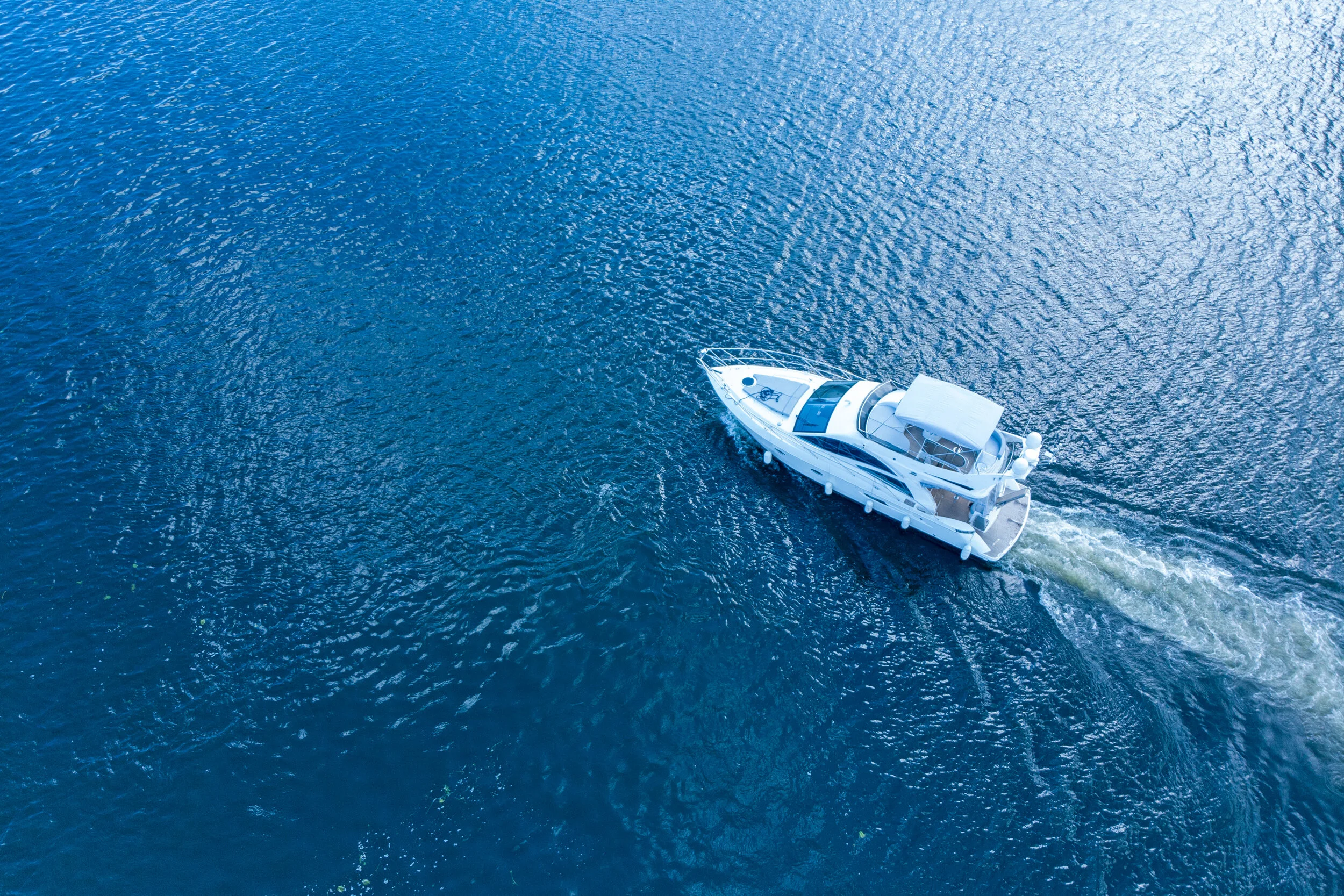 Motorboat-racing-through-the-river-in-sunlight.-Top-view-1049449612_3868x2579.jpeg