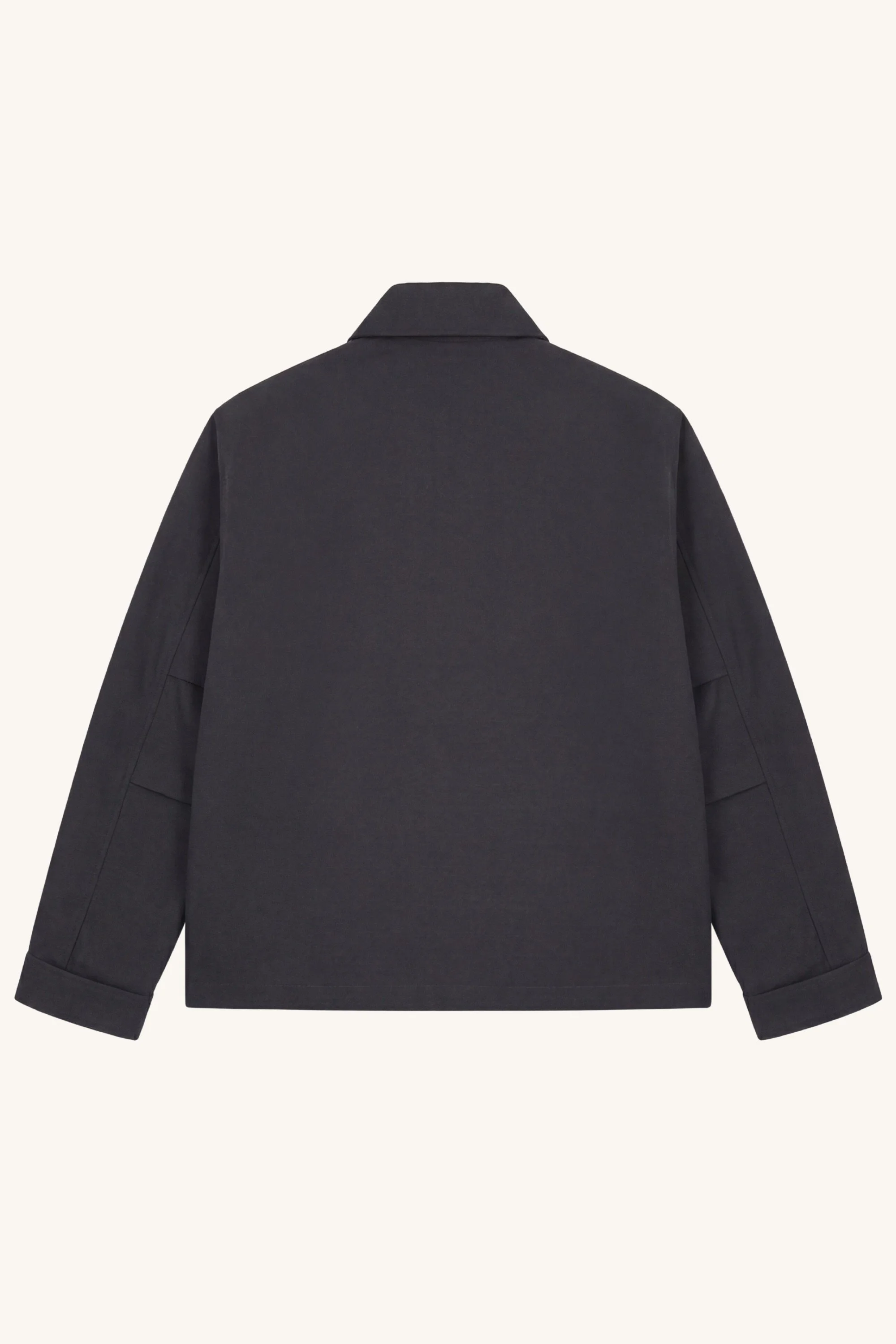 Back view of the [ko'lon] Navigator Jacket in black cotton ripstop showing a clean rear panel, relaxed silhouette, and adjustable cuff construction.