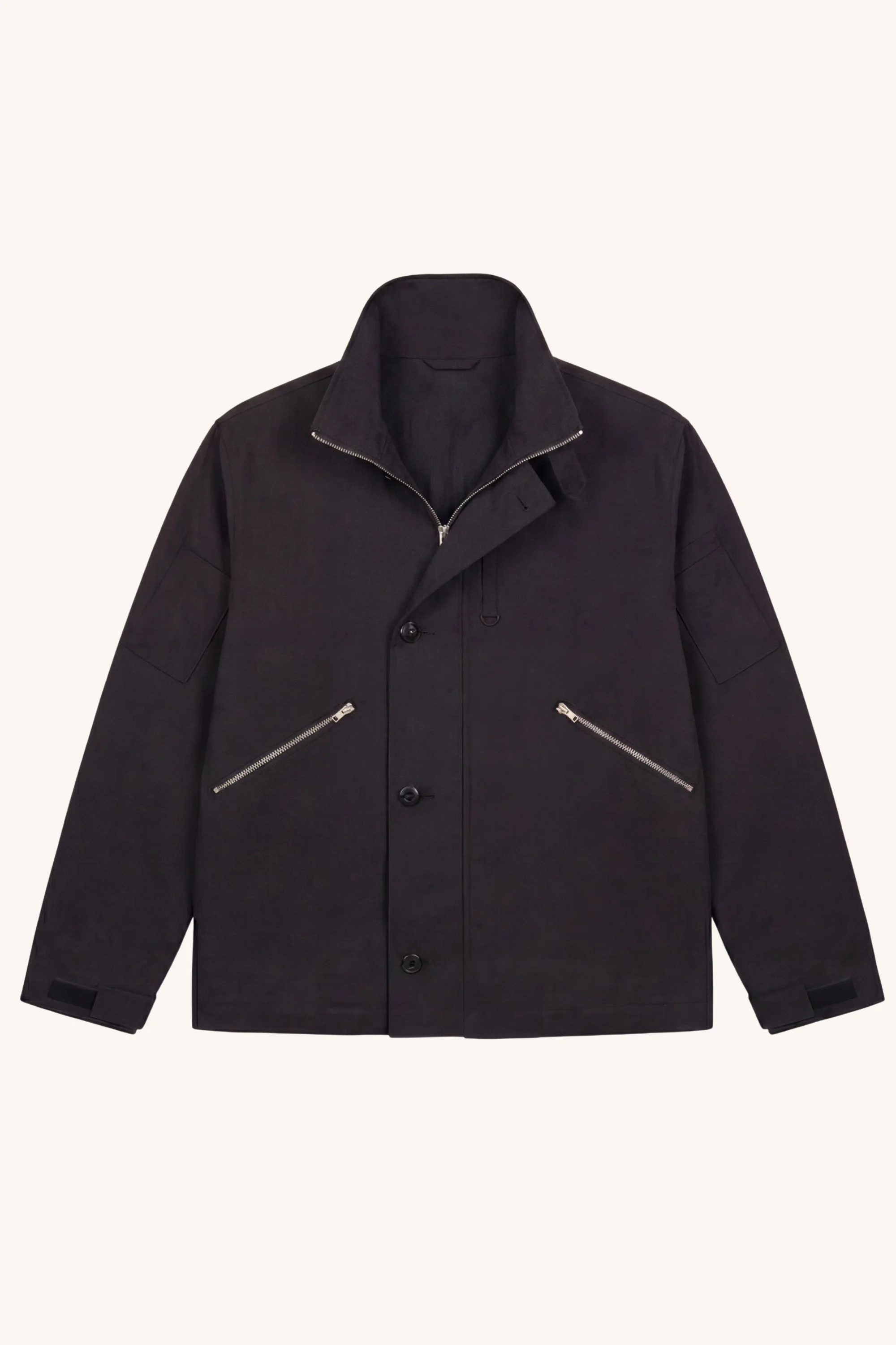 Front view of the [ko'lon] Navigator Jacket in black cotton ripstop with stand collar open, concealed zip closure, utility pocket detailing, and relaxed fit.