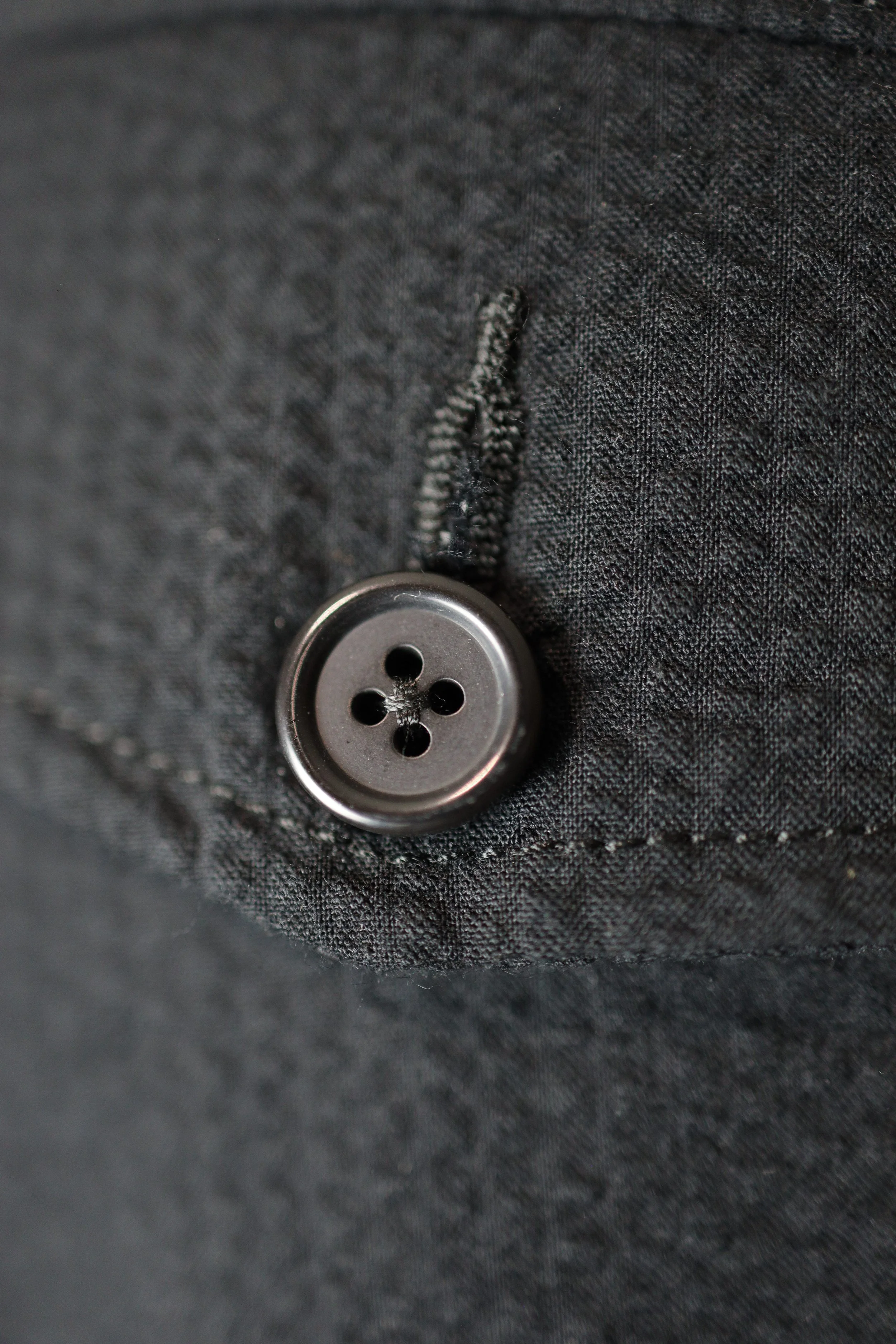 Close‑up of seersucker cotton fabric showing textured weave and button detail.