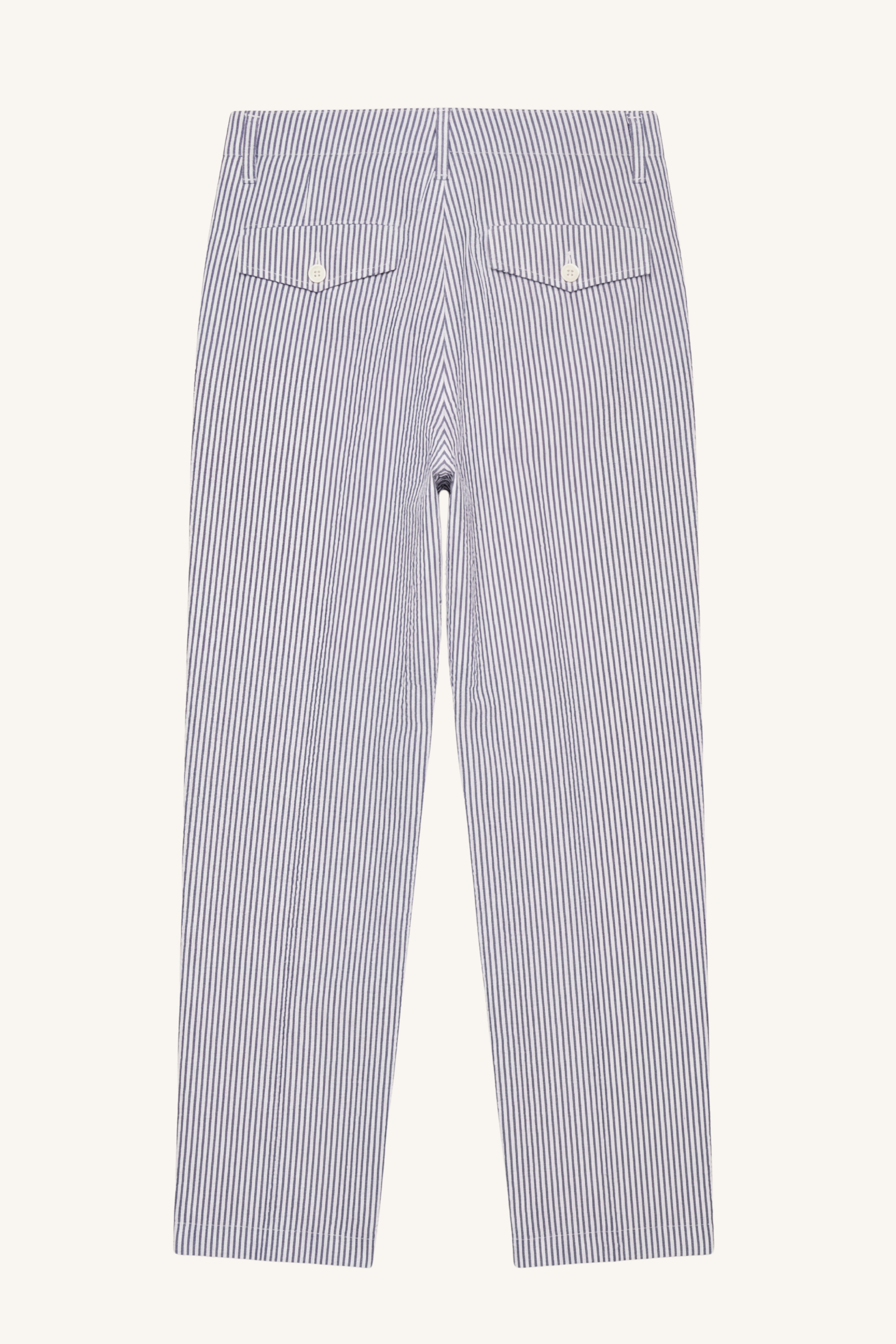 Back view of [ko'lon] indigo seersucker military chino featuring buttoned flap back pockets, clean construction, and straight‑leg profile