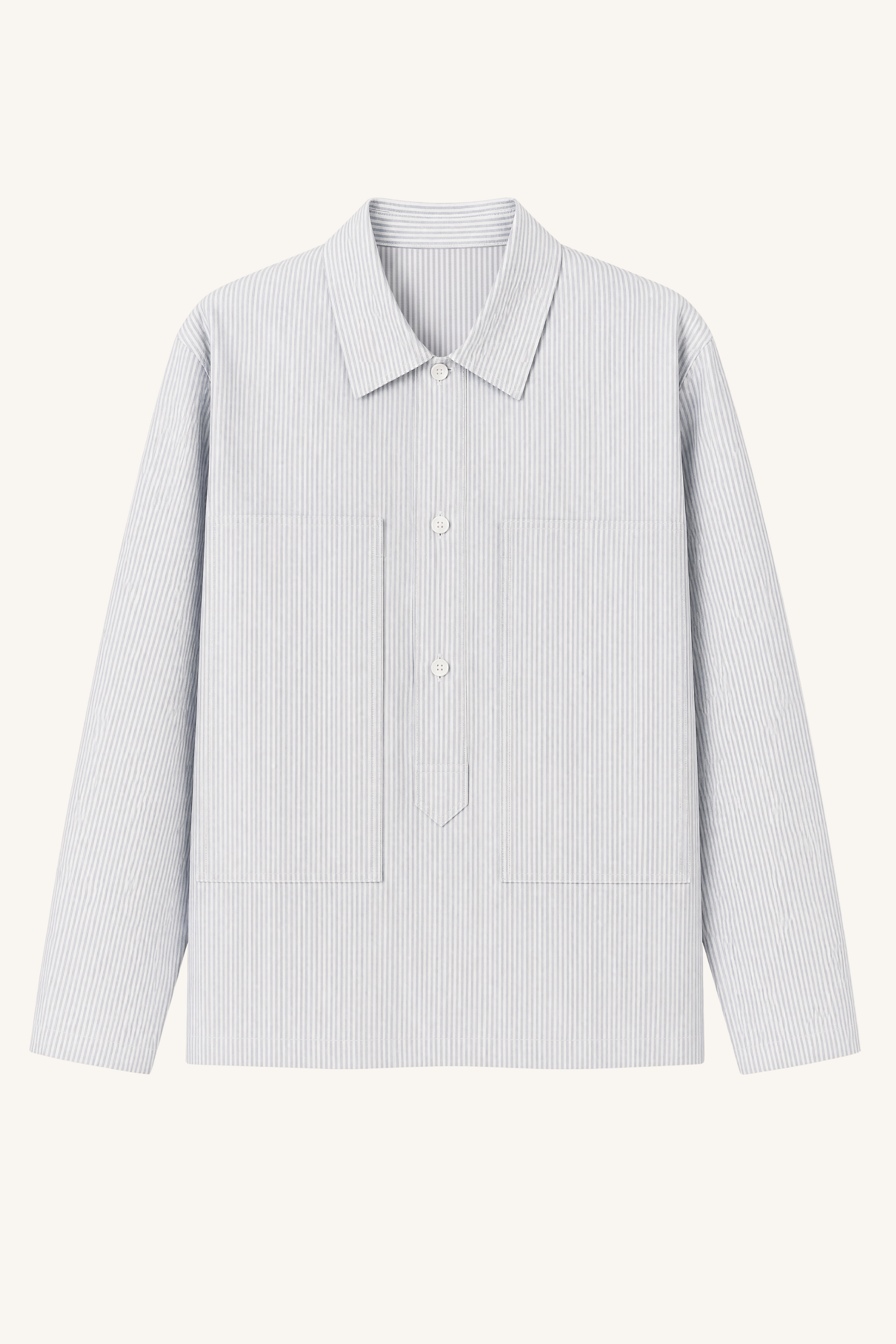 Ocean Blue Cotton Oxford Pullover Shirt laid flat, featuring blue-and-white striped Oxford fabric, oversized utility pockets, a structured collar, and a relaxed contemporary silhouette.